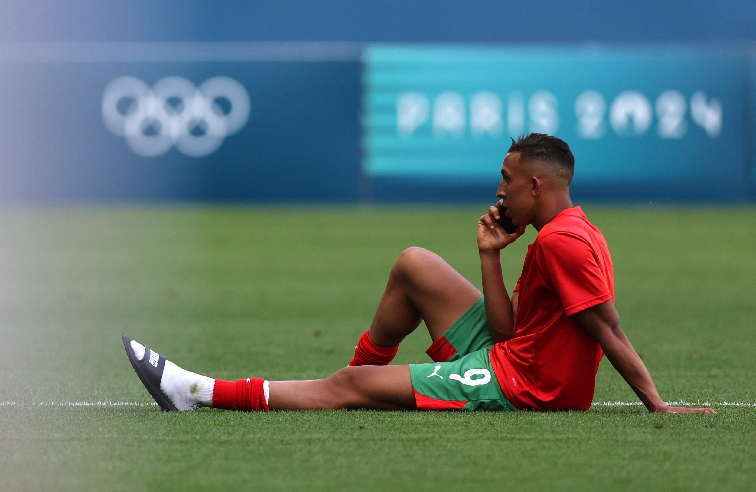 Otra de las escenas insólitas de la primera jornada de los Juegos Olímpicos. El delantero marroquí Soufiane Rahimi habla por teléfono en el campo de juego tras el partido del escándalo ante la Argentina (REUTERS/Thaier Al-Sudani)