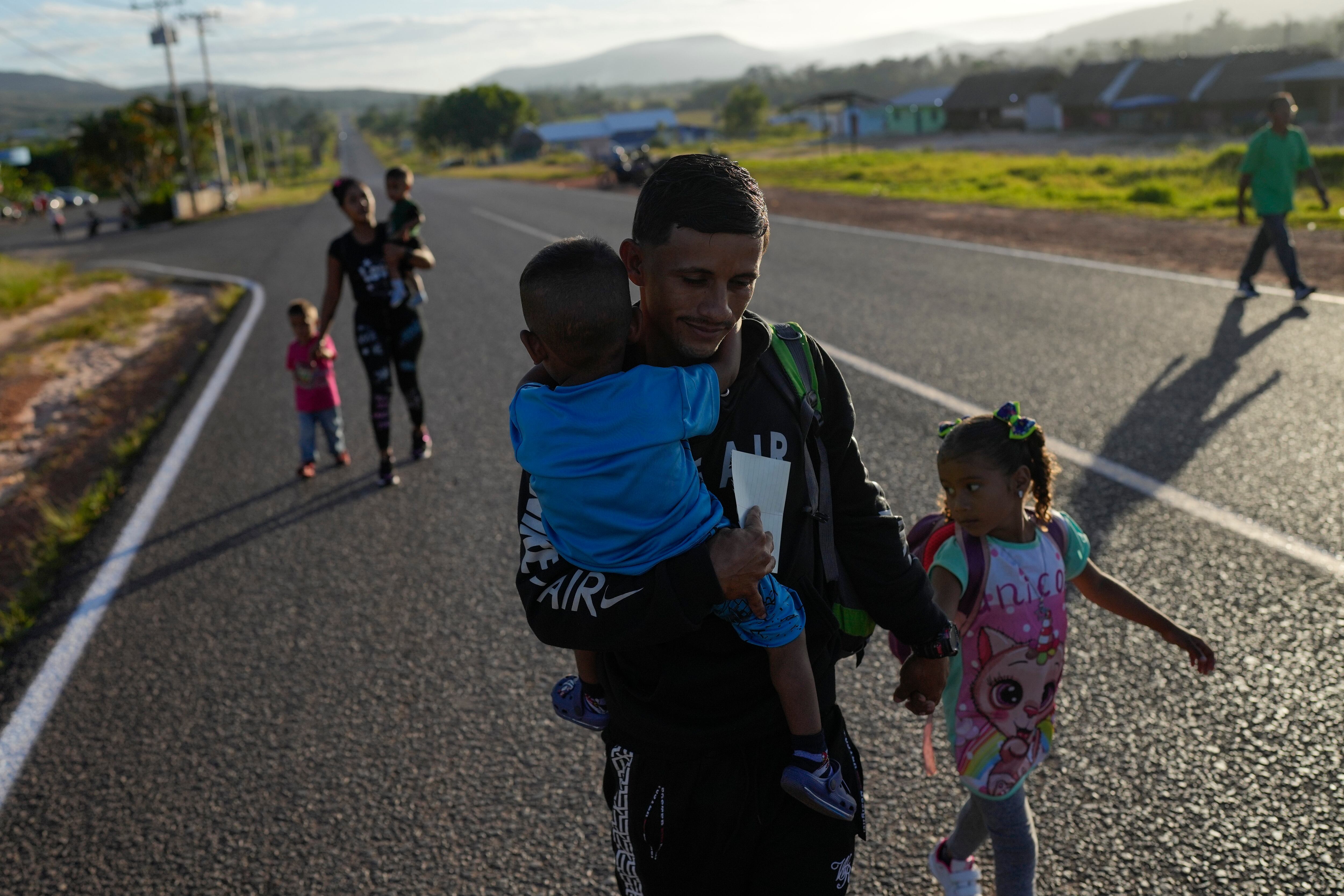 Miguel González y su familia, todos de origen venezolano, caminan en Santa Elena, Venezuela, hacia el transporte que los llevará a la frontera con Brasil (AP Foto/Matias Delacroix/Archivo)