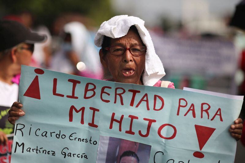 Una mujer sostiene una pancarta durante una protesta para exigir la liberación de las personas detenidas durante el estado de emergencia   (REUTERS/Jose Cabezas)