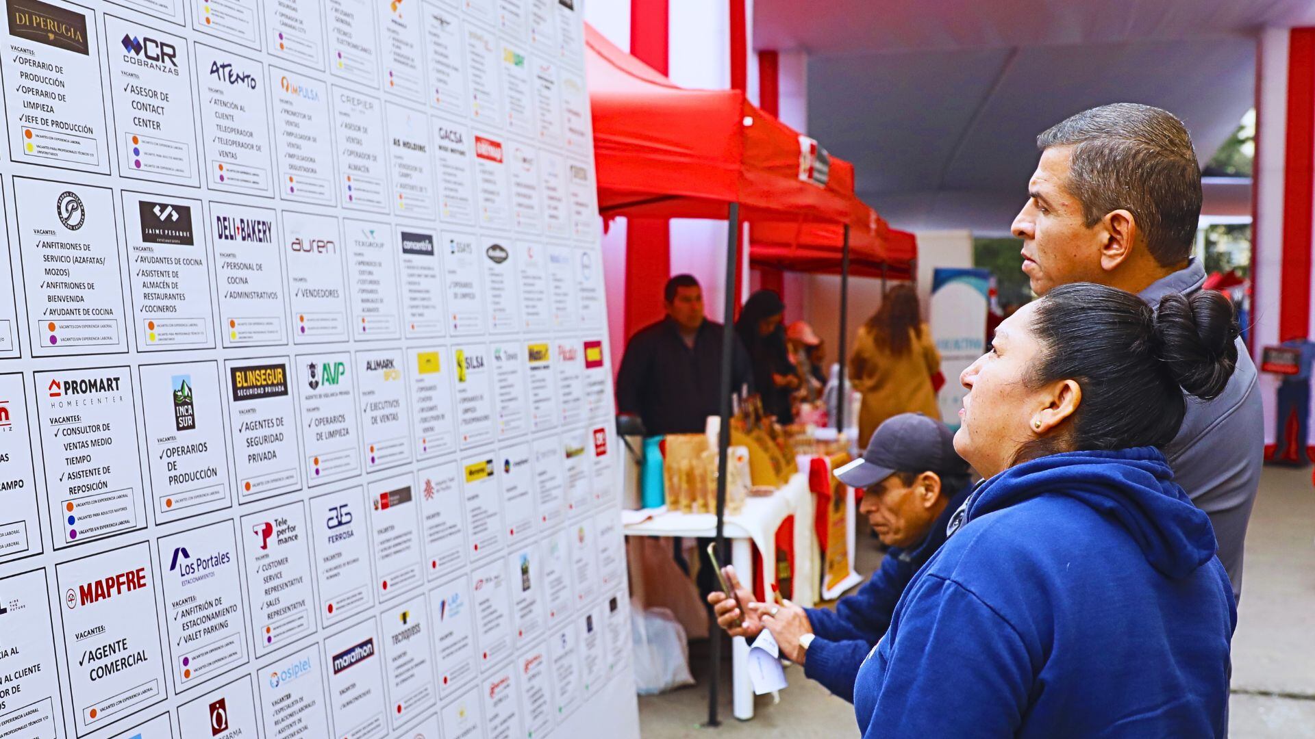 Gente mirando a pared con avisos de trabajo