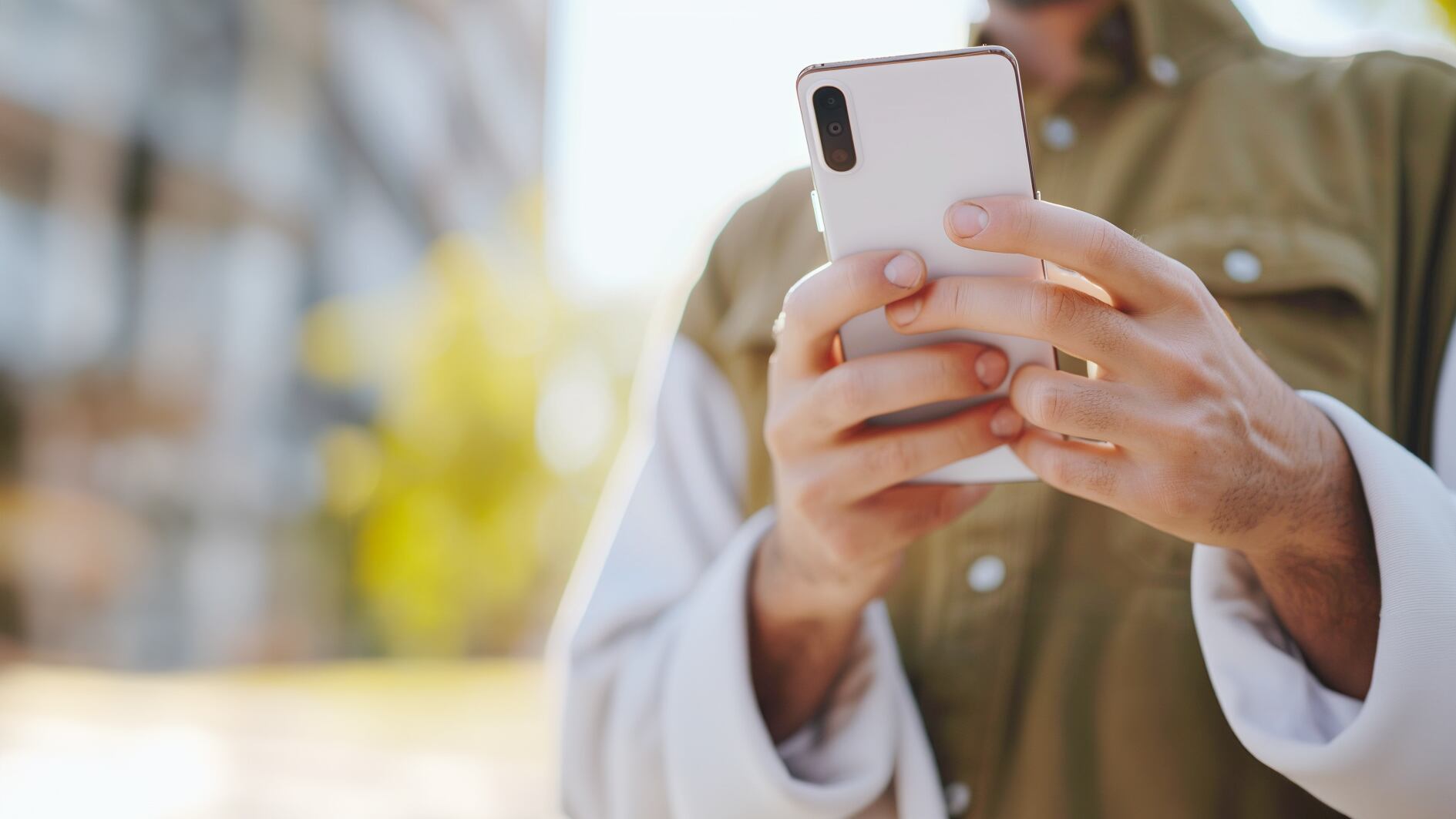 Un hombre adulto revisa su celular en la calle - (Imagen Ilustrativa Infobae)