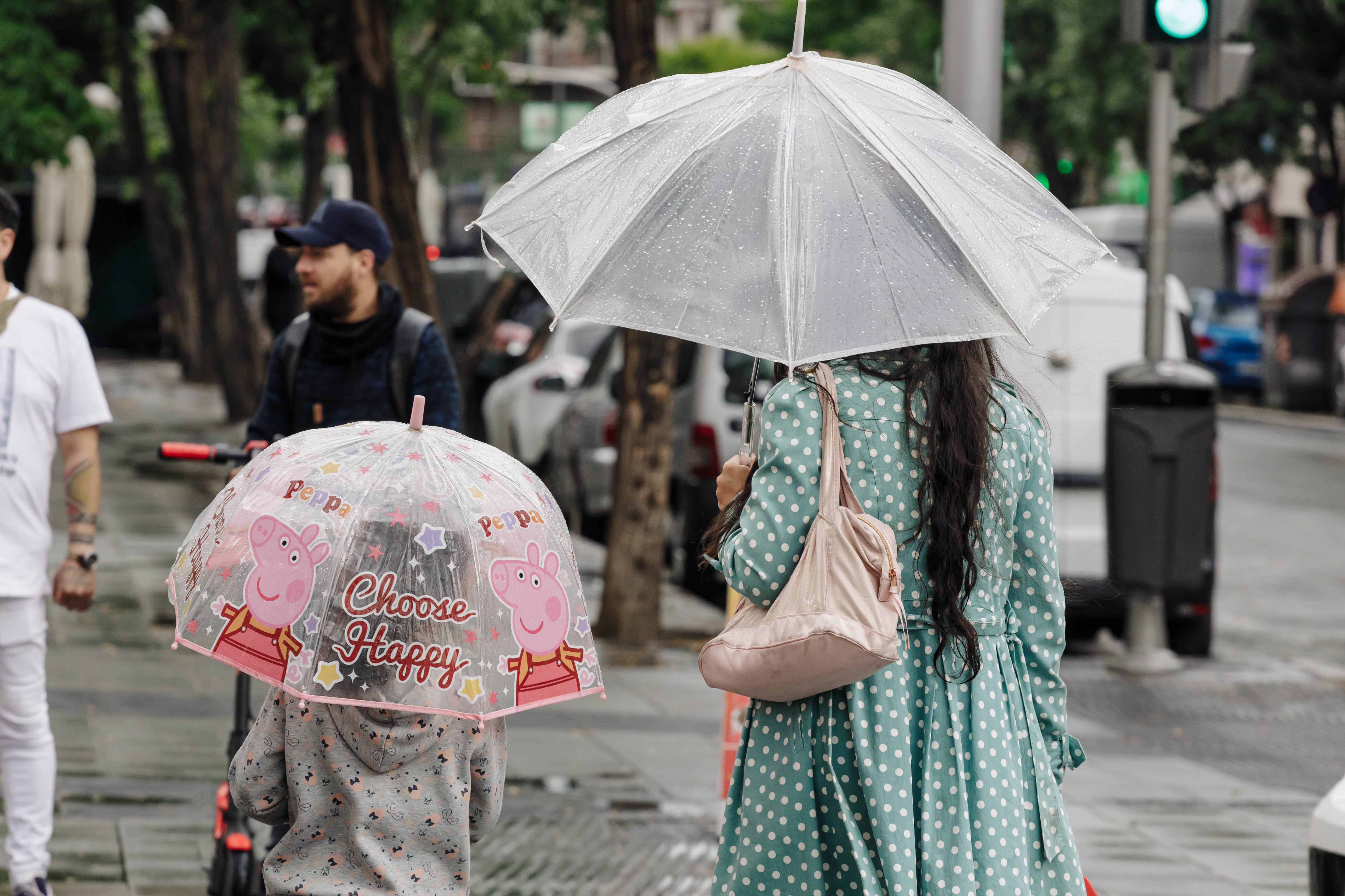 Una mujer y un niño pasean con un paraguas, en Madrid (Archivo/Europa Press/Carlos Luján).