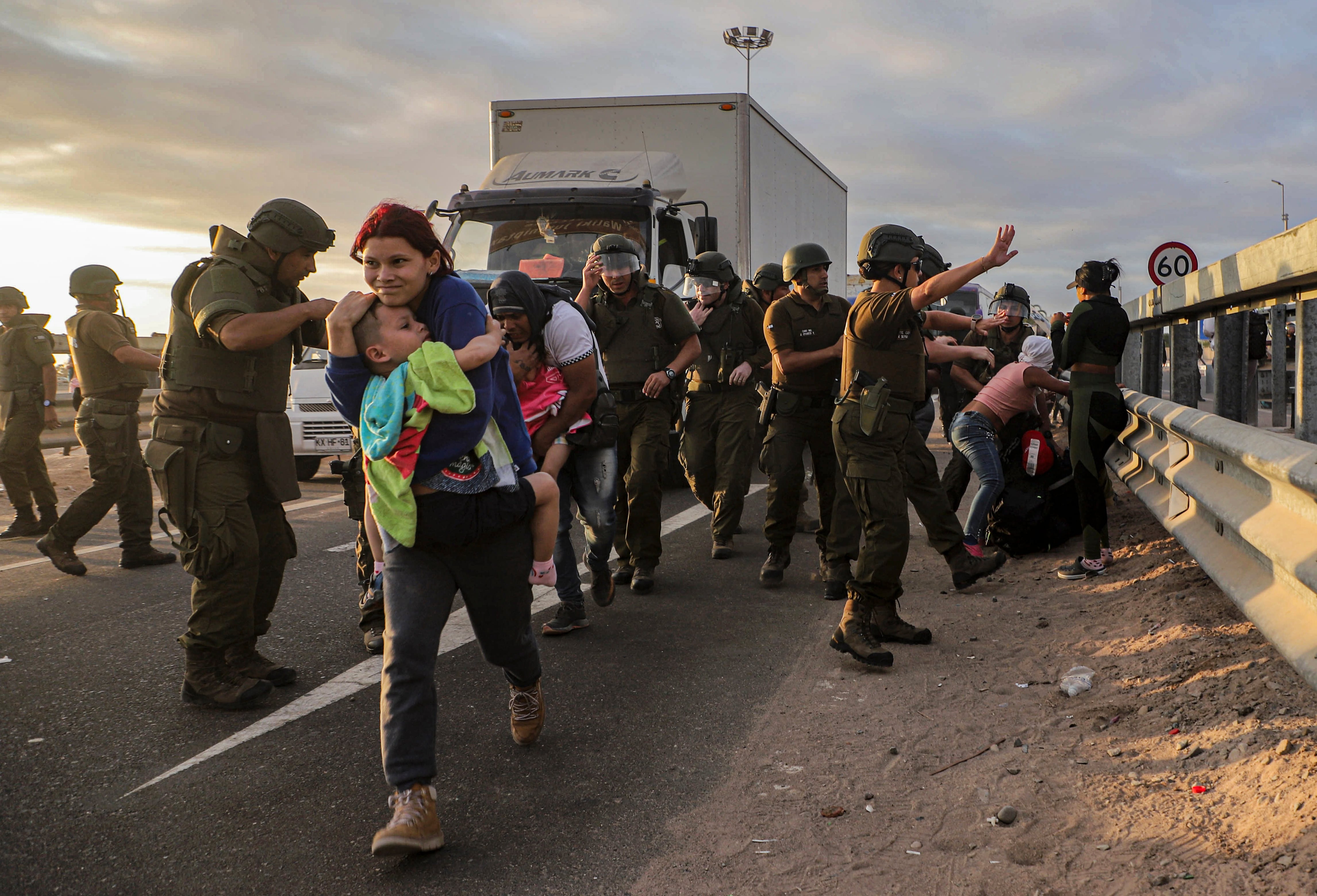 Migrantes que bloquean la carretera en la frontera entre Chile y Perú son dispersados por la policía chilena cerca de Arica, Chile.