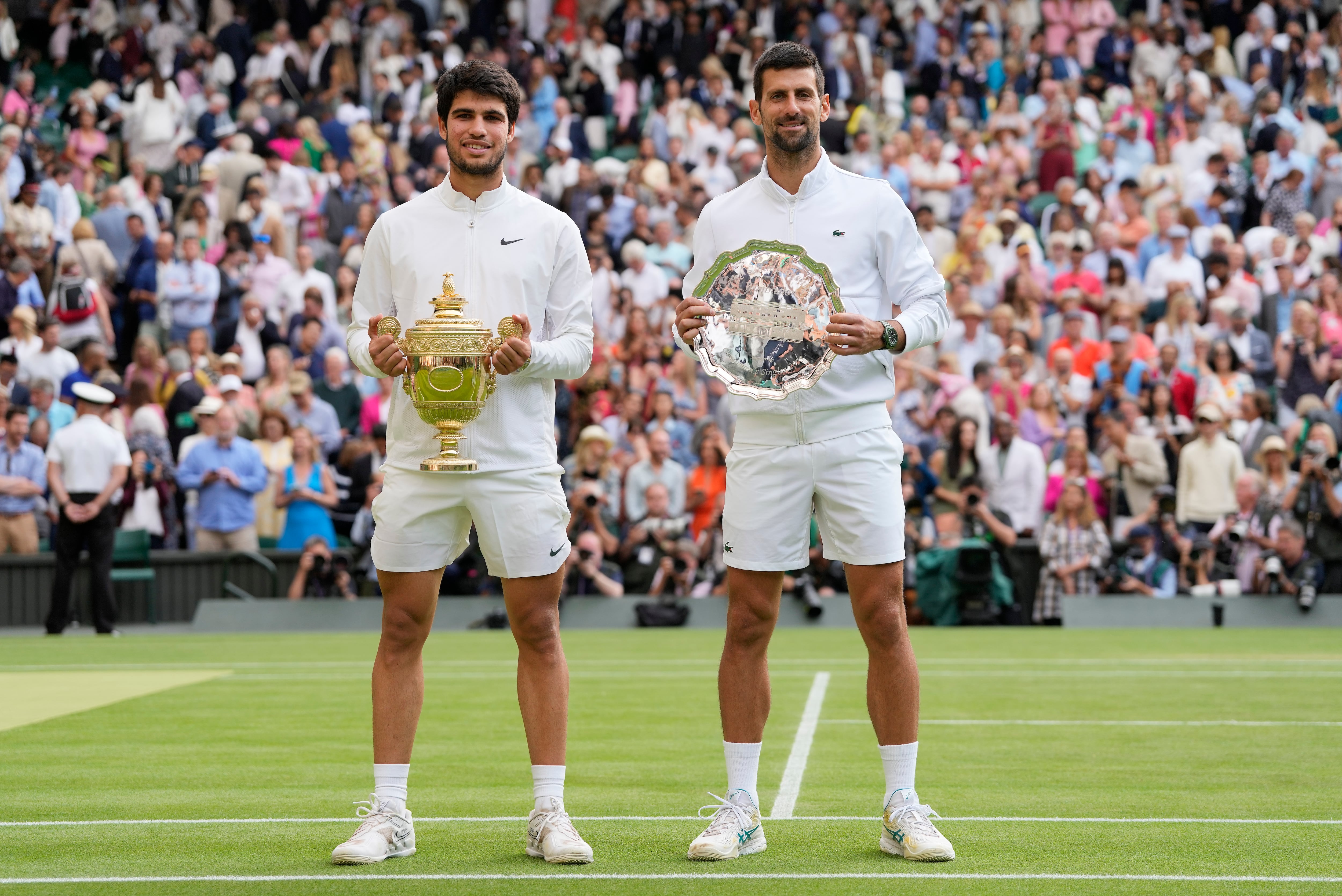El campeón Carlos Alcaraz posa junto a Novak Djokovic tras la final de Wimbledon, el domingo 16 de julio de 2023, en Londres. (AP Foto/Kirsty Wigglesworth)