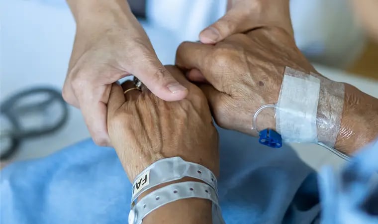 Un médico toma de las manos a un paciente con cáncer - Terapia del dolor (UPCH)