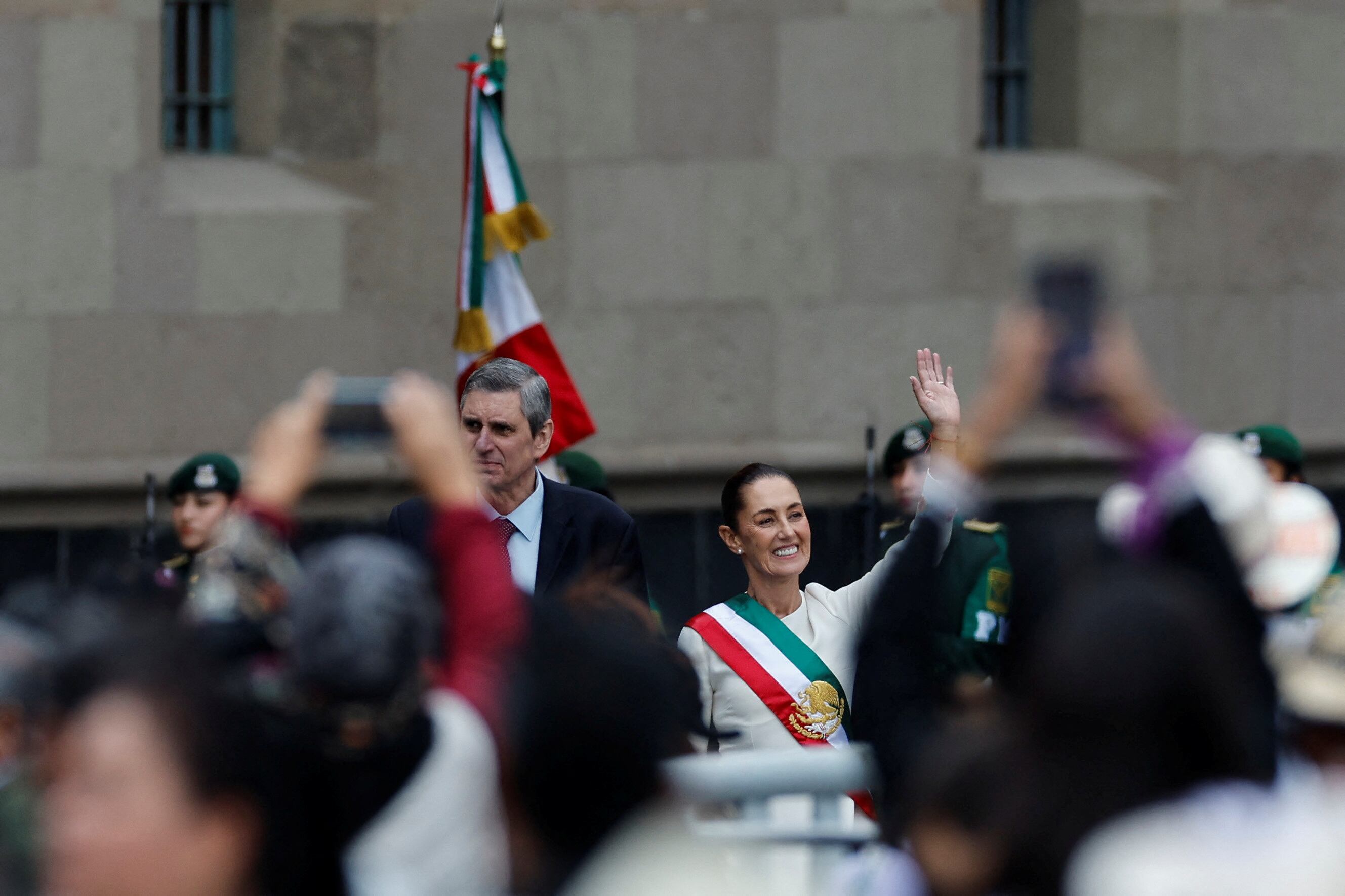 Mexico's new President Claudia Sheinbaum waves next to Jesus Maria Tarriba during a ceremony where she receives the "baton of command", at Zocalo Square in Mexico City, Mexico October 1, 2024. REUTERS/Daniel Becerril