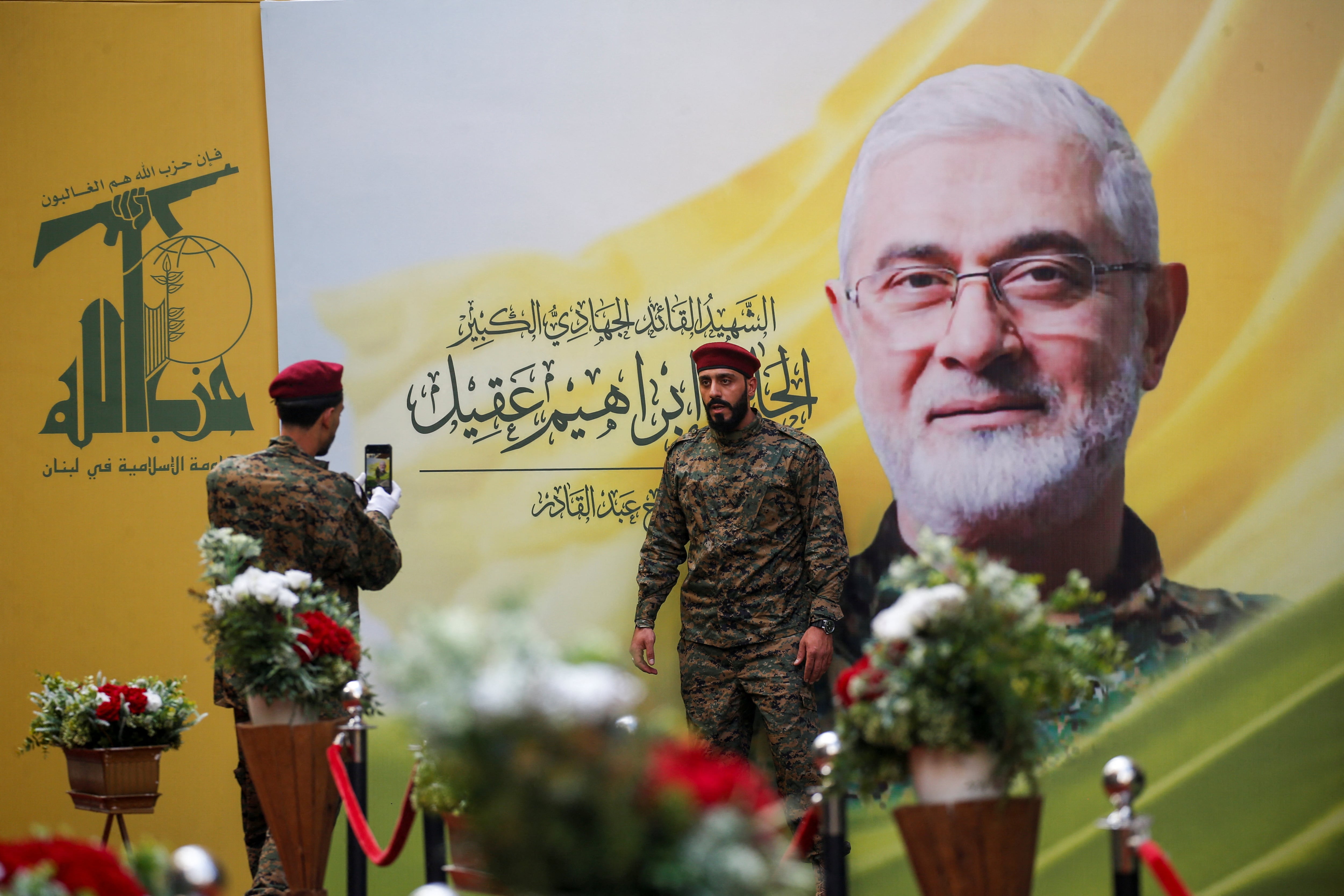 Un terrorista posa junto a una foto del comandante de Hezbollah Ibrahim Aqil, ejecutado en un ataque aéreo israelí en los suburbios del sur de Beirut el 20 de septiembre pasado (Reuters)