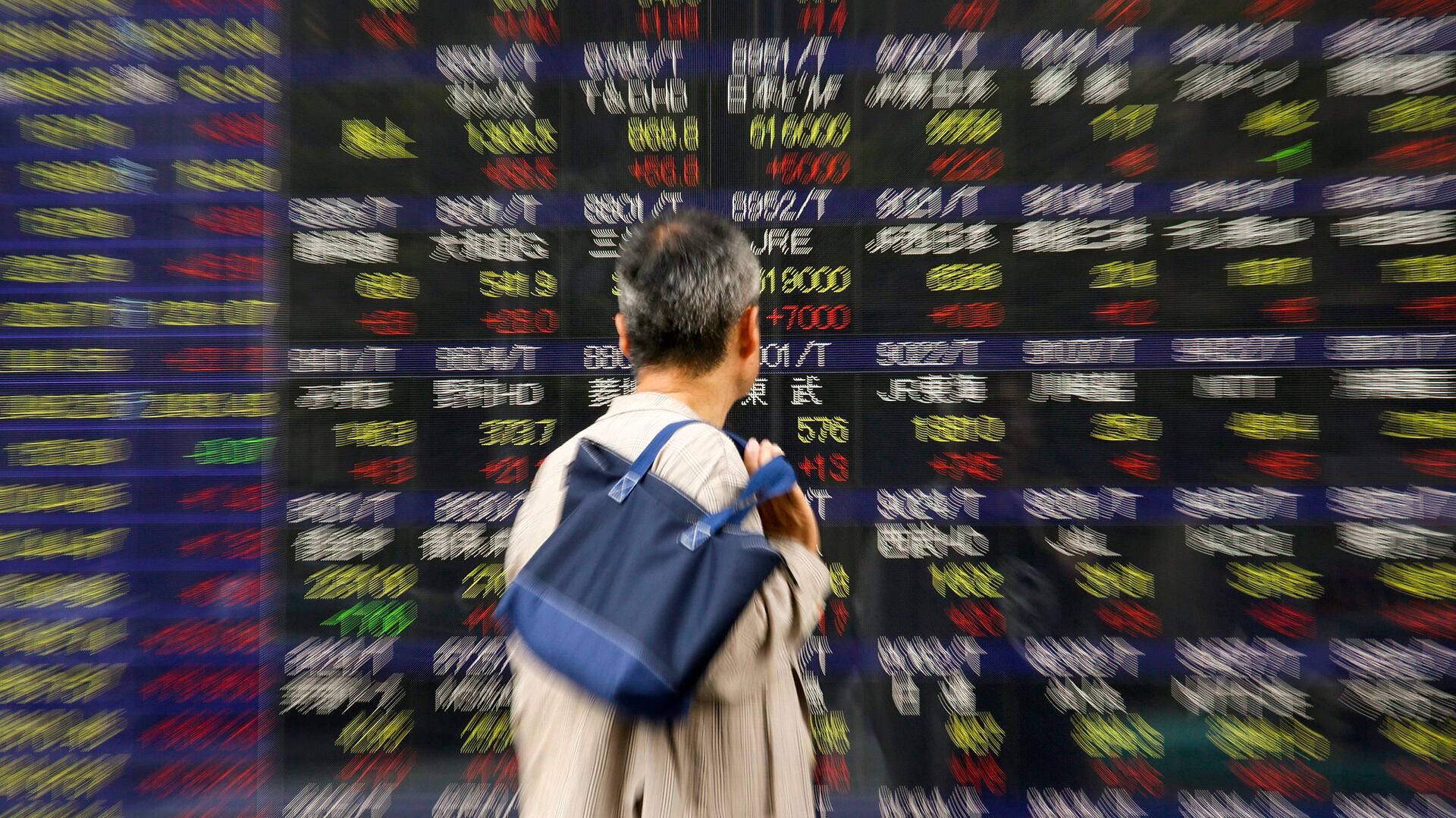 Un peatón observa un panel con la información del cierre del índice de referencia Nikkei, en Tokio (EFE)