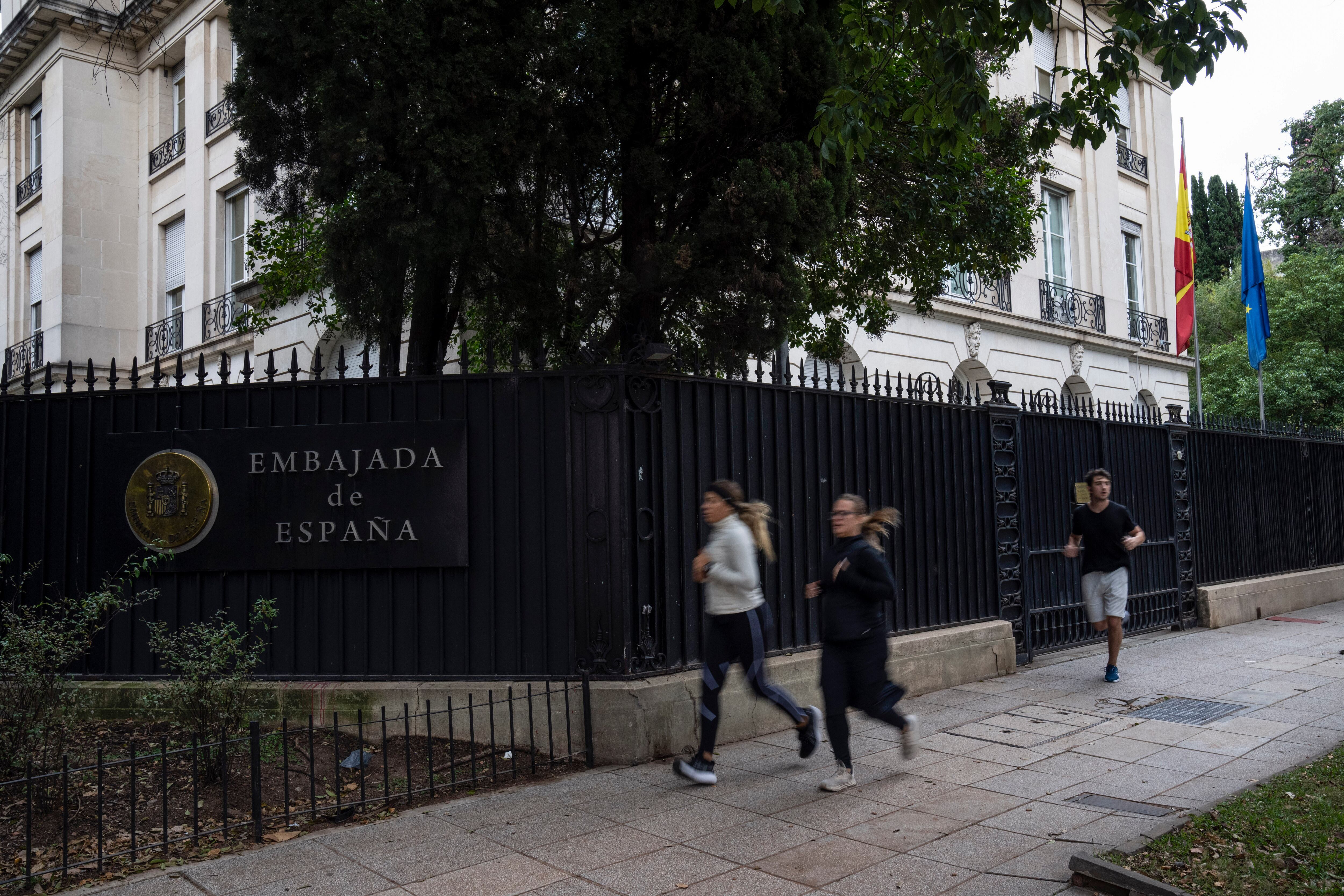 La gente pasa corriendo frente a la embajada de España en el barrio de Palermo de Buenos Aires, Argentina, el martes 21 de mayo de 2024. (AP Foto/Rodrigo Abd)