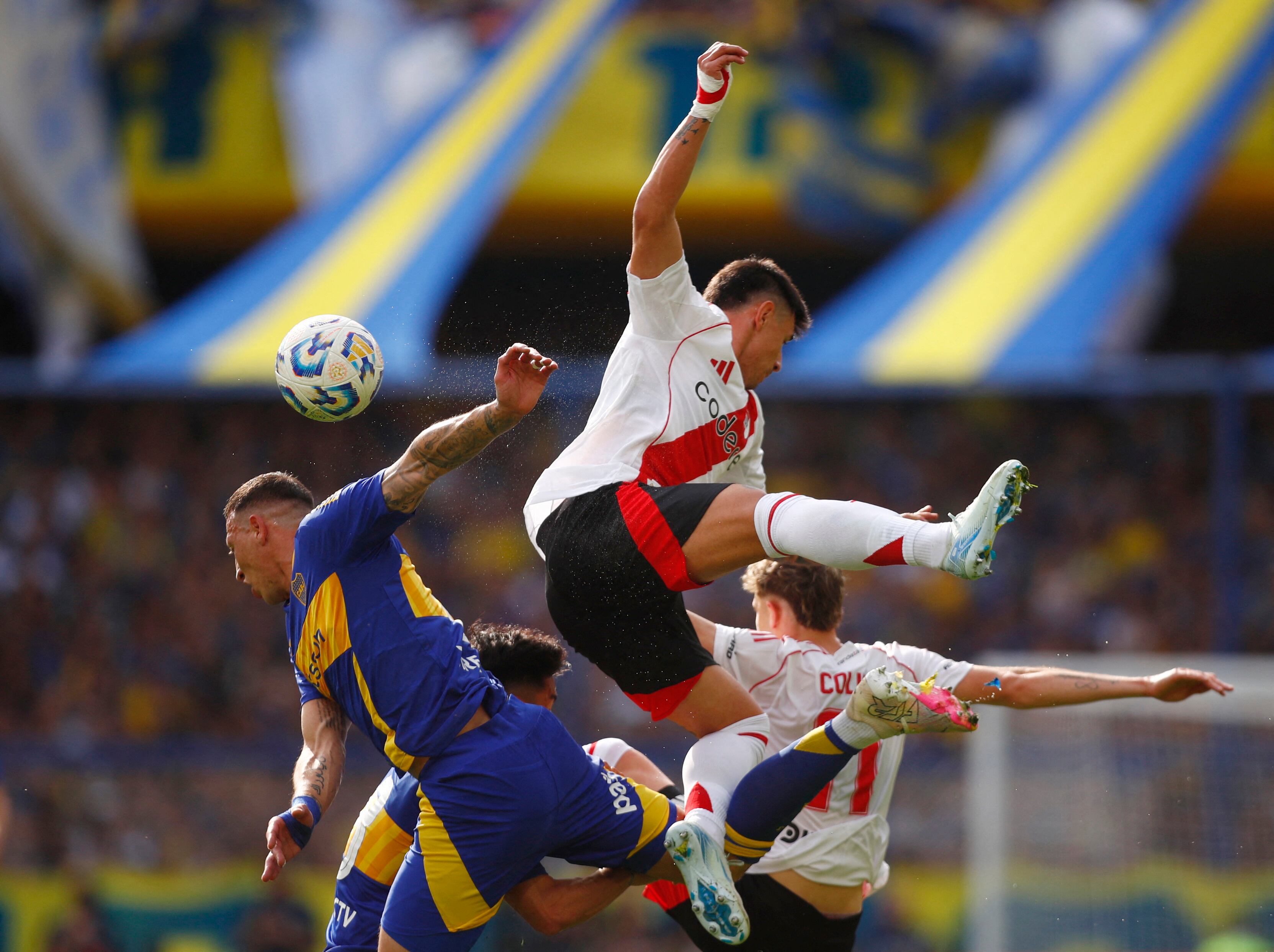 Jugadores de Boca y River peleando en una jugada aérea