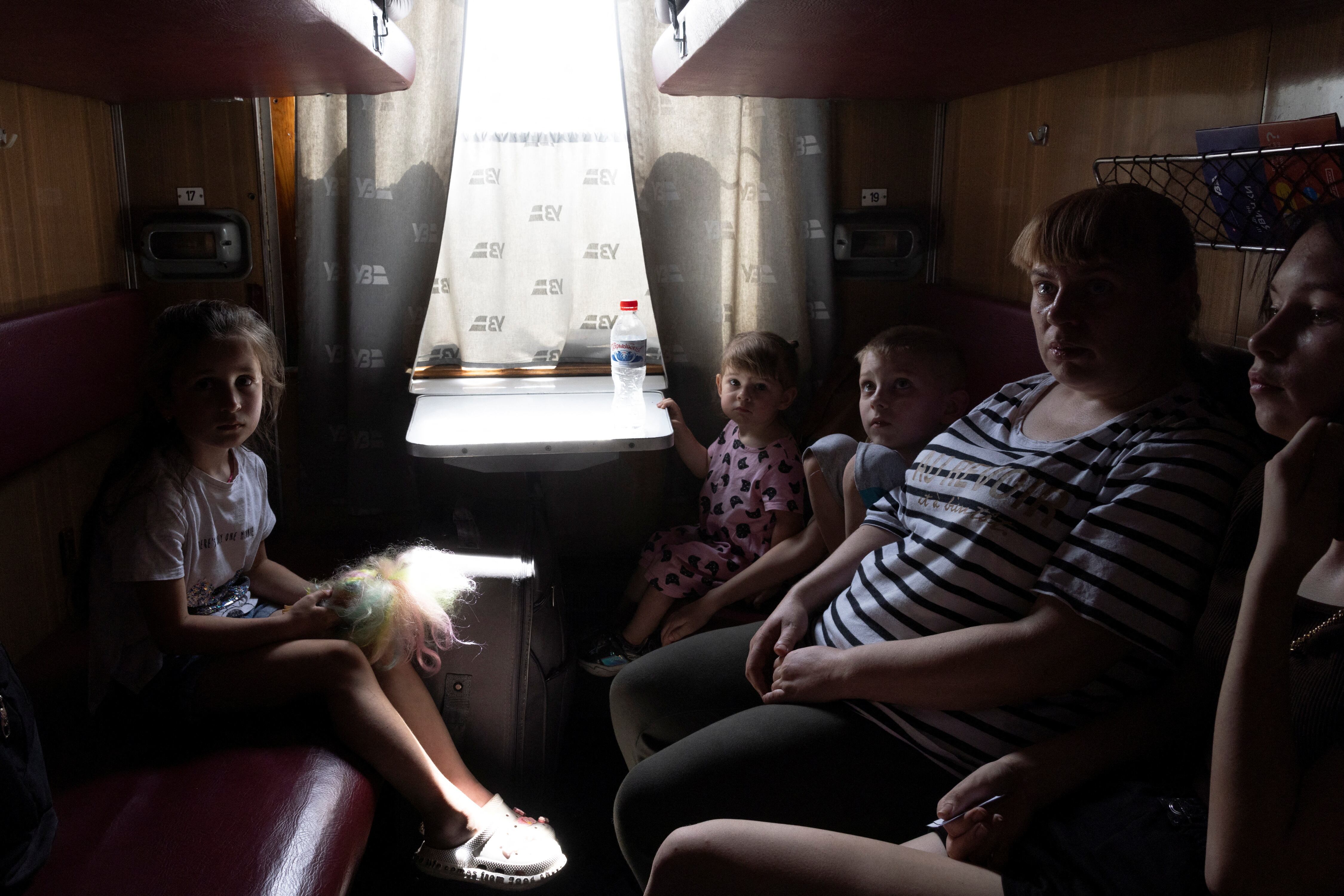 Una familia que debió abandonar Pokrovsk abordo de un tren (REUTERS/Thomas Peter)