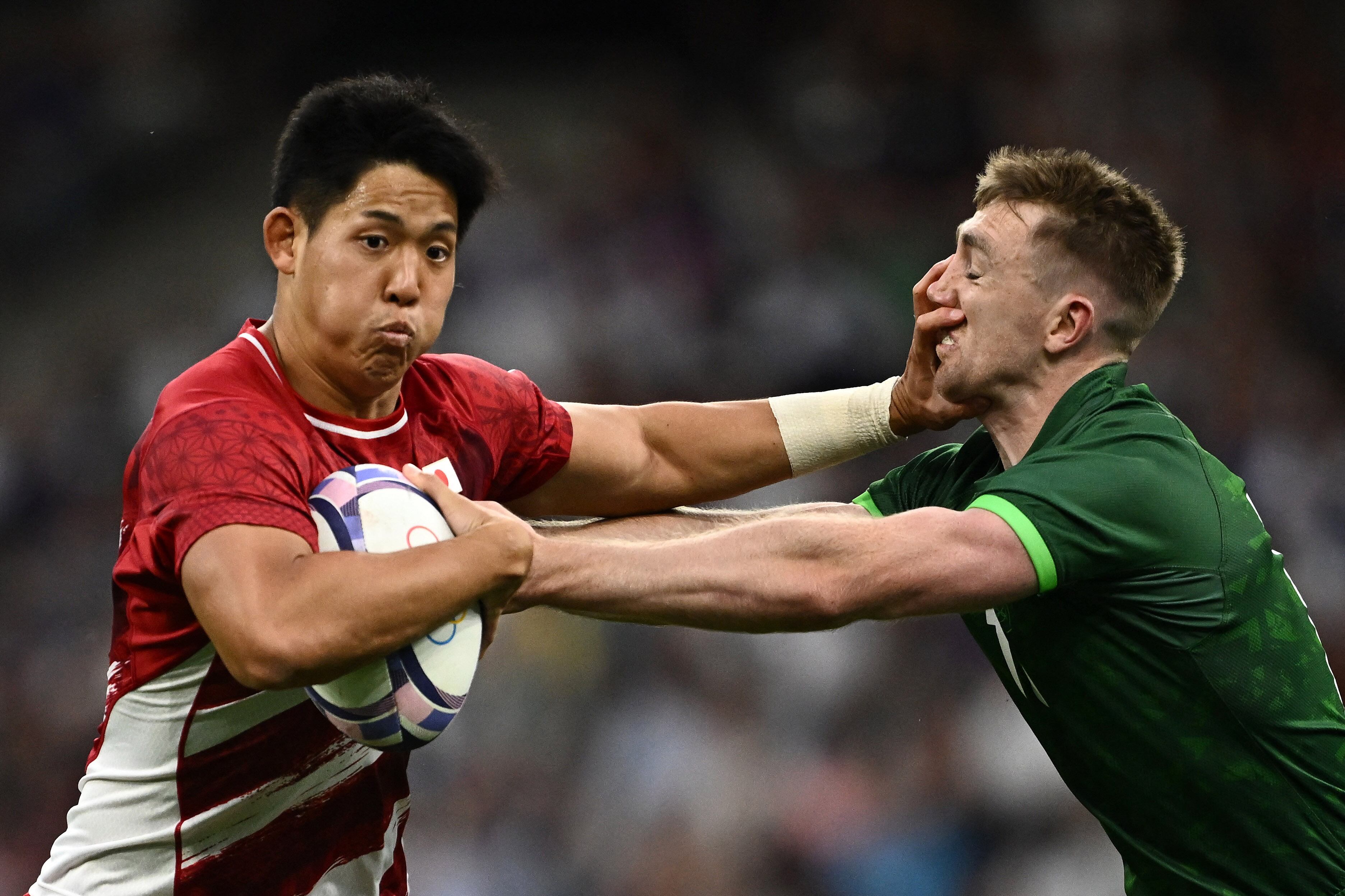 El japonés Takamasa Maruo le pone la mano en la cara al irlandés Chay Mullins, durante el partido de rugby 7 en París 2024 (REUTERS/Dylan Martinez)