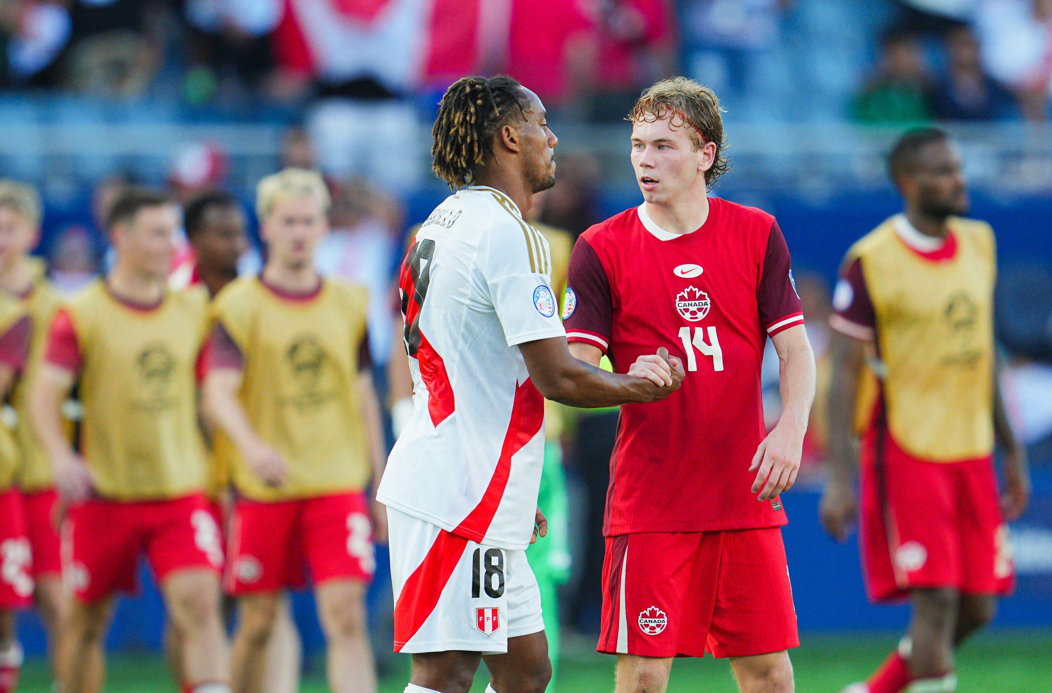 Jun 25, 2024; Kansas City, MO, USA; Canada forward Jacob Shaffelburg (14) greets Peru midfielder Andre Carrillo (18) after a Copa America match at Children's Mercy Park. Mandatory Credit: Jay Biggerstaff-USA TODAY Sports