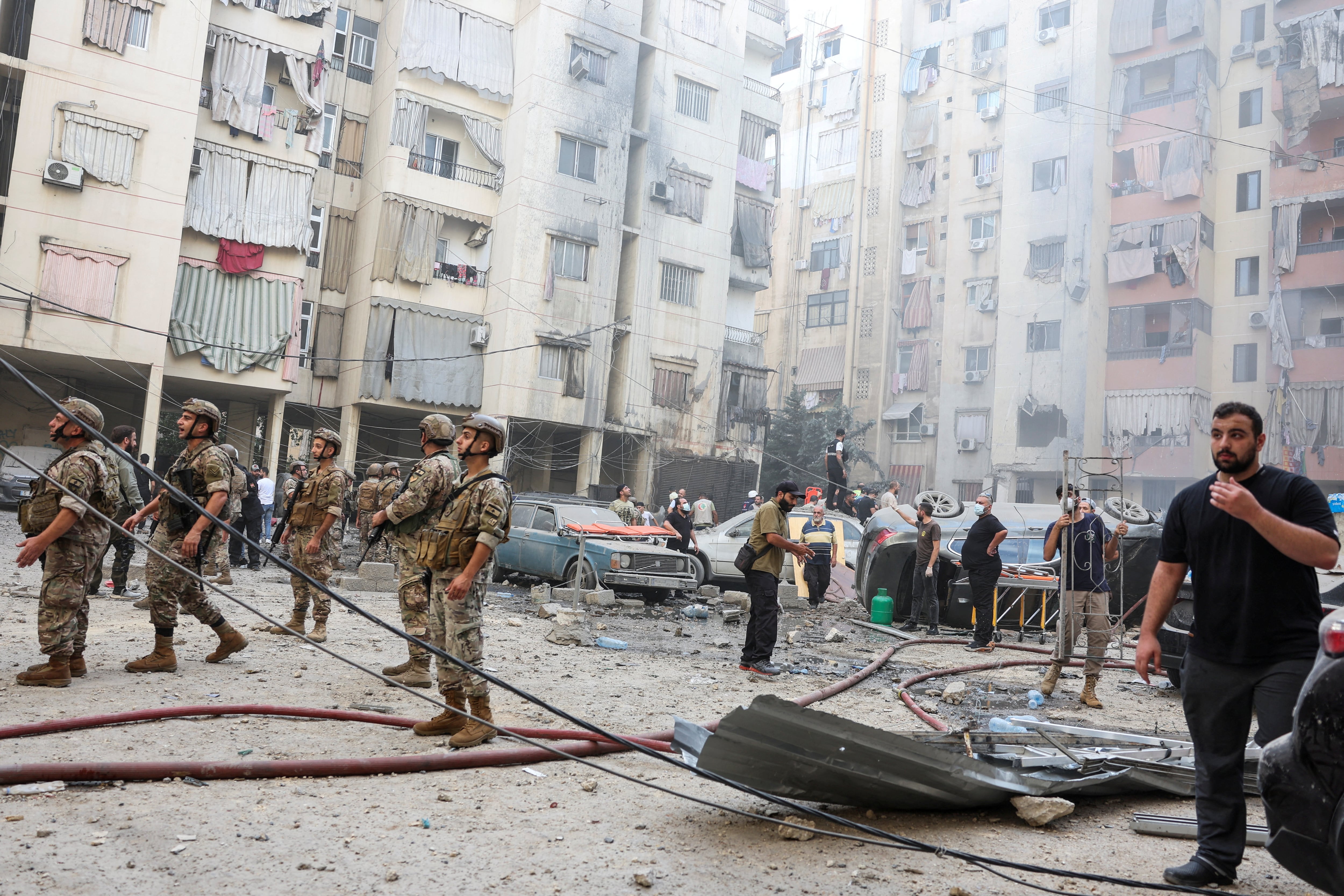 Personas y miembros del ejército inspeccionan el lugar de un ataque israelí en los suburbios del sur de Beirut, Líbano (REUTERS/Mohamed Azakir)