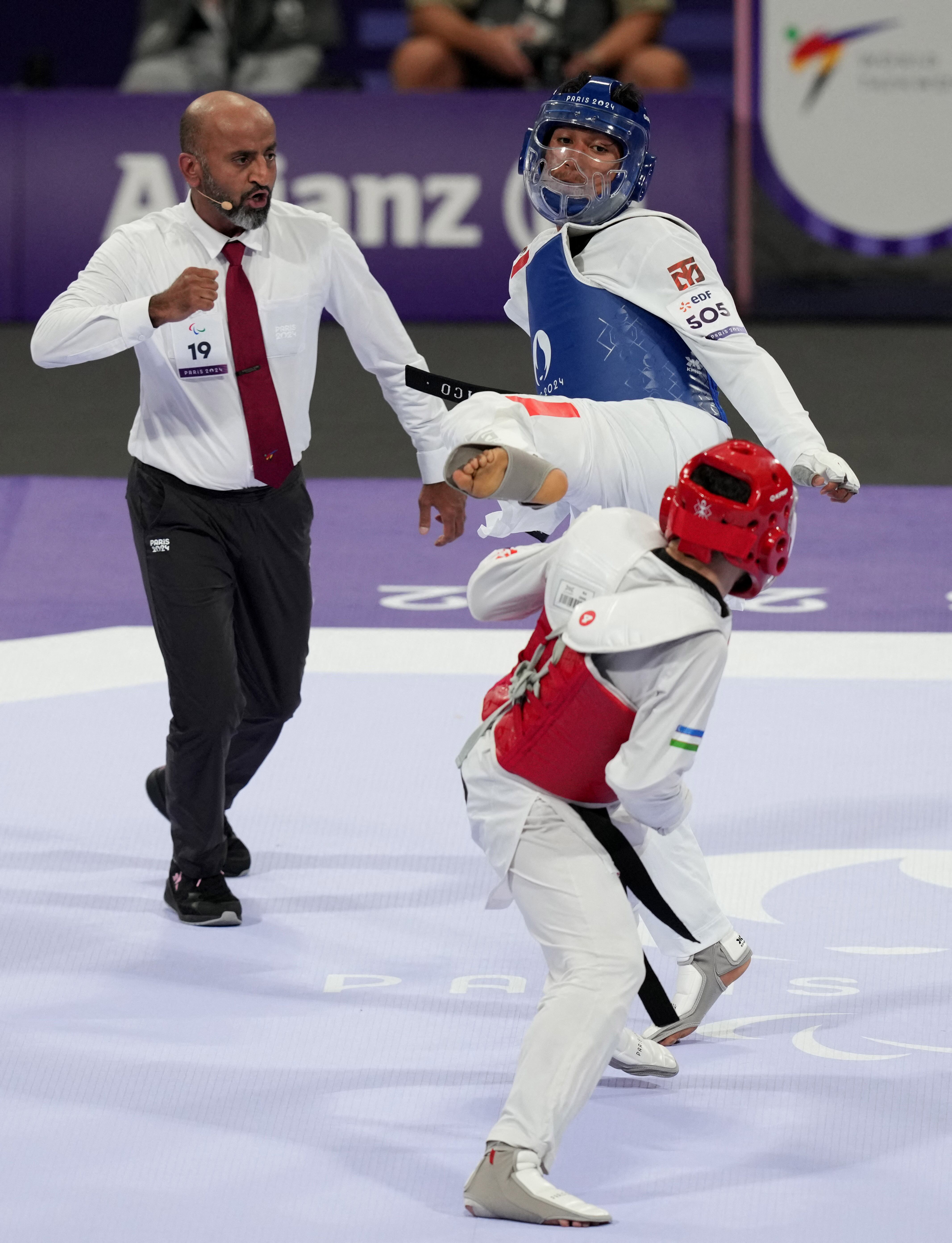 Paris 2024 Paralympics - Taekwondo - Men K44 -70kg Quarterfinal - Grand Palais, Paris, France - August 30, 2024 Juan Diego Garcia Lopez of Mexico in action against Javokhir Alikulov of Uzbekistan next to referee Taufique Ahmad Rana REUTERS/Maja Smiejkowska