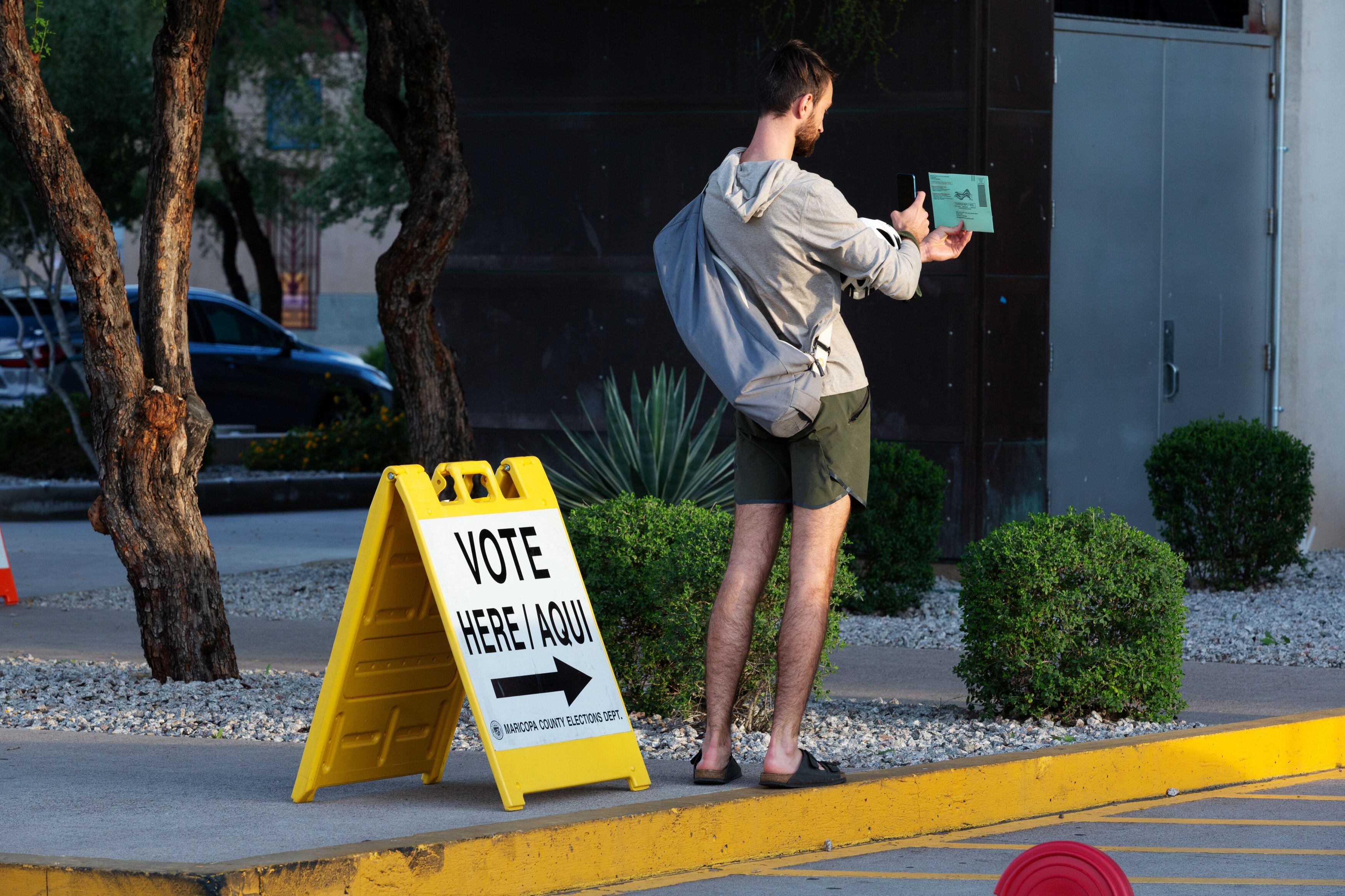 Colin Dueker, de 26 años, fotografía su papeleta antes de depositarla en la Biblioteca Burton Barr de Phoenix, durante las primarias demócratas en Arizona (REUTERS/Cheney Orr)