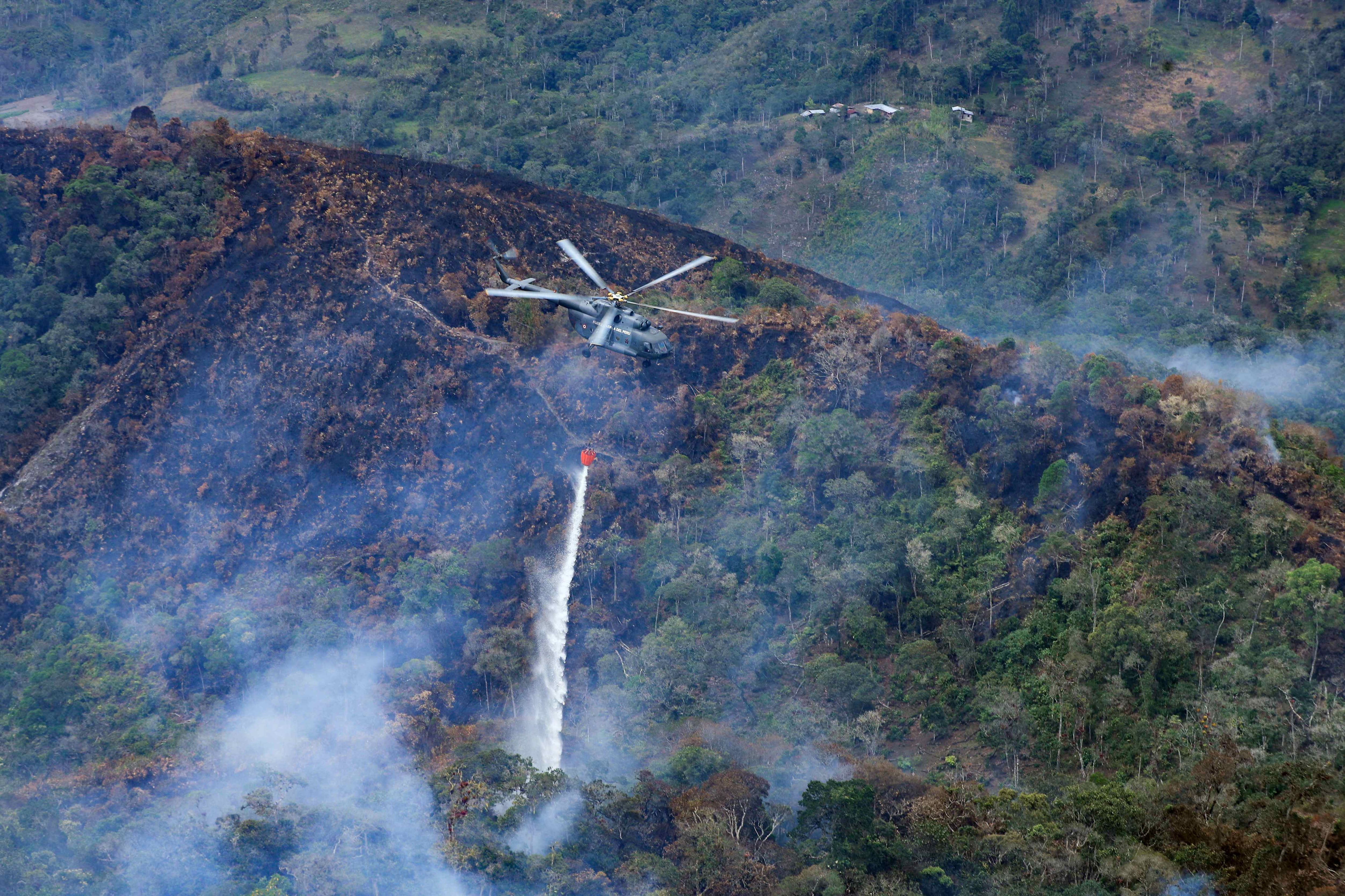 Fotografía cedida por la presidencia de Perú del desplazamiento de un helicóptero con sistema Bambi bucket en la zona de la Florida en Amazonas, en Perú. EFE/ Presidencia de Perú
