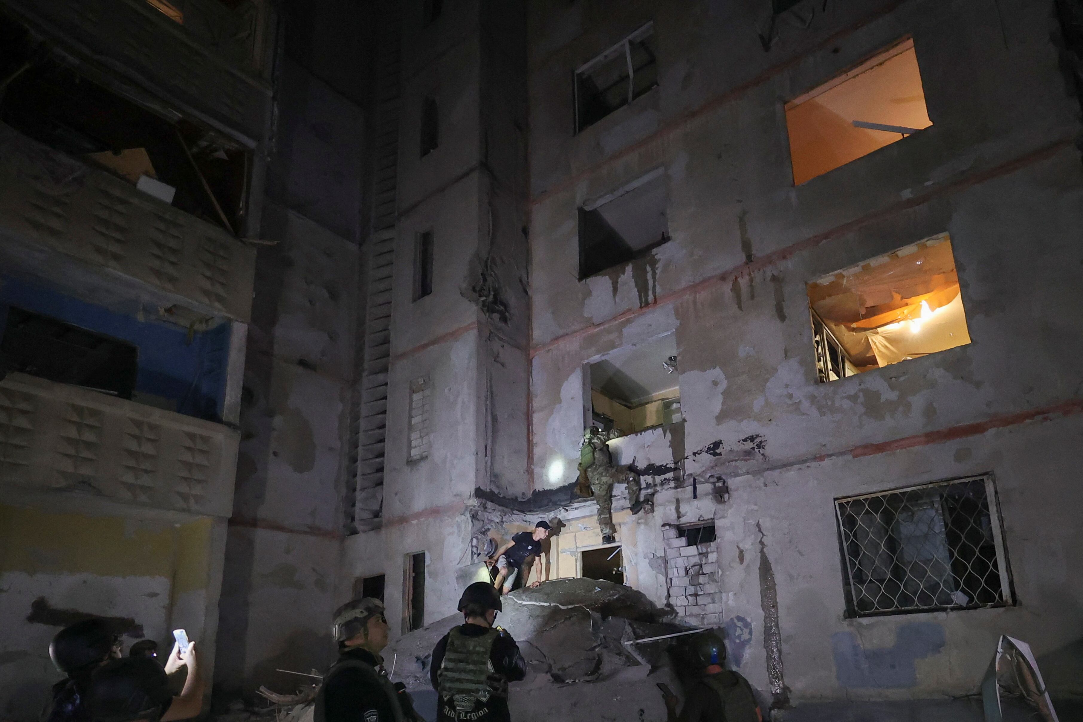 Empleados de emergencias trabajan en el solar de un edificio de apartamentos alcanzado por un ataque aéreo ruso (REUTERS/Vyacheslav Madiyevskyy)