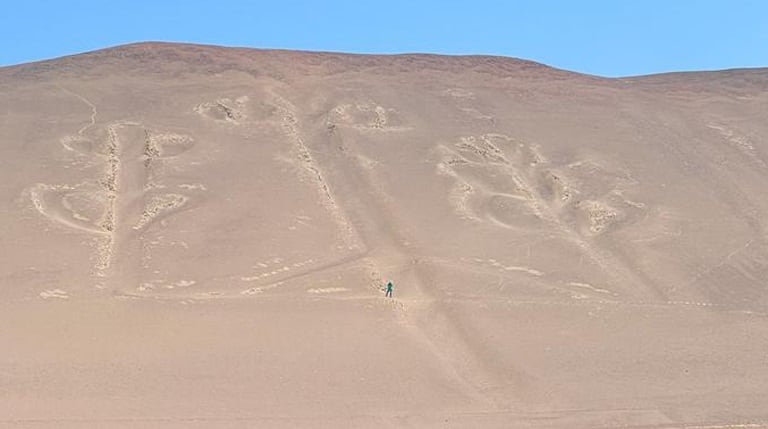 Fotografía cedida este martes, 22 de enero, por el Ministerio de Cultura de Perú en la que se registró a una persona que camina sobre el geoglifo 'El candelabro de Paracas'. EFE/Ministerio de Cultura de Perú
