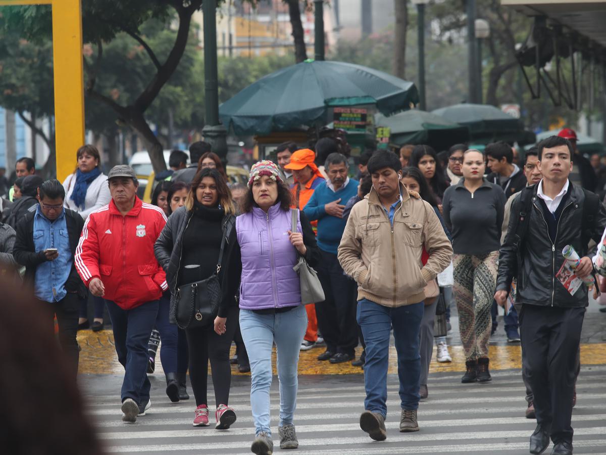 Un grupo de personas cruza una calle del Cercado de Lima, en medio de un día de otoño, con temperaturas por debajo de los 16 grados.