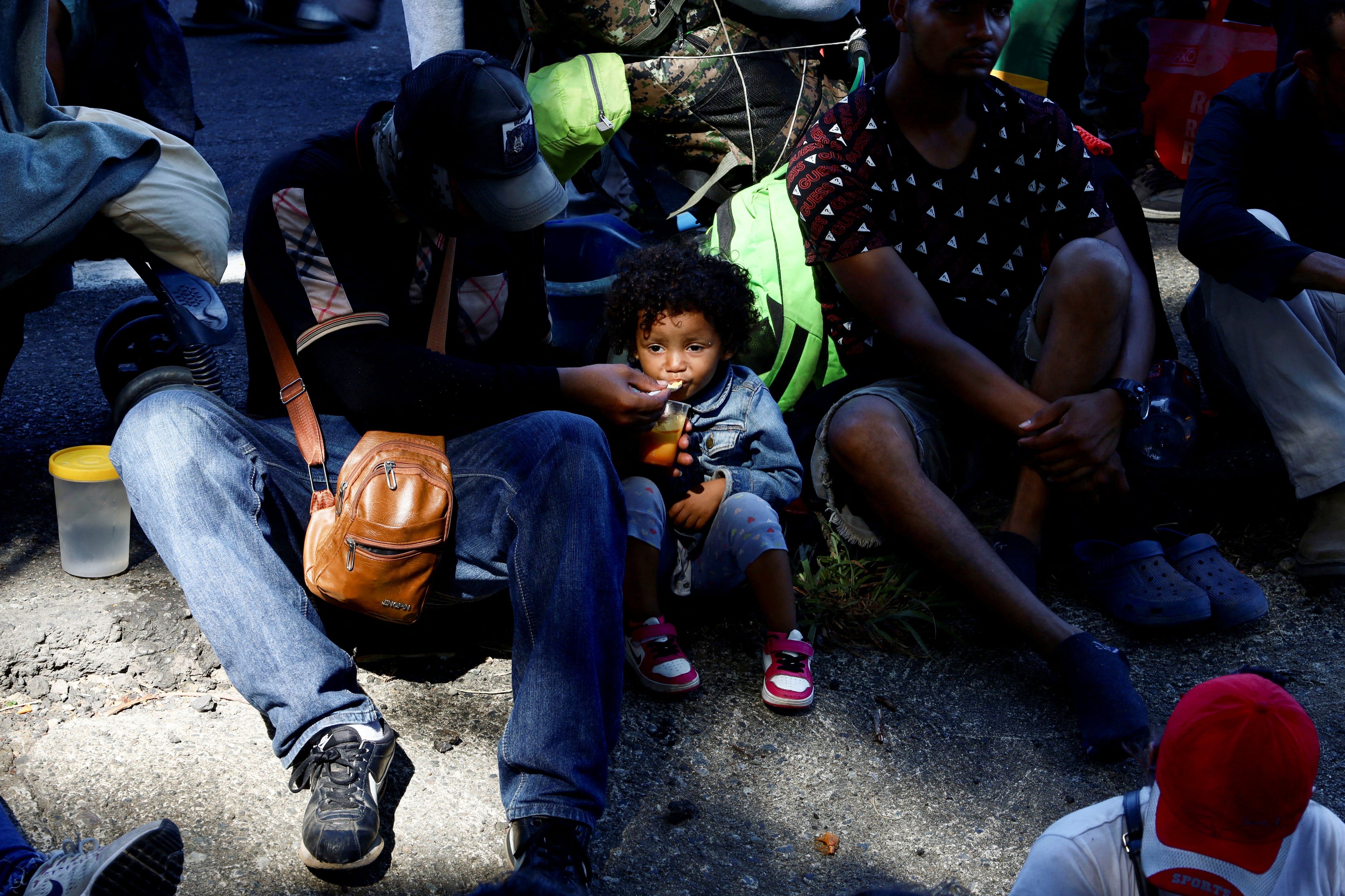 Un migrante venezolano alimenta a su hijo mientras viajan hacia la frontera con Estados Unidos en una caravana llamada "El Vía Crucis del Migrante", en Huixtla, México, el 27 de marzo de 2024. REUTERS/Jose Torres