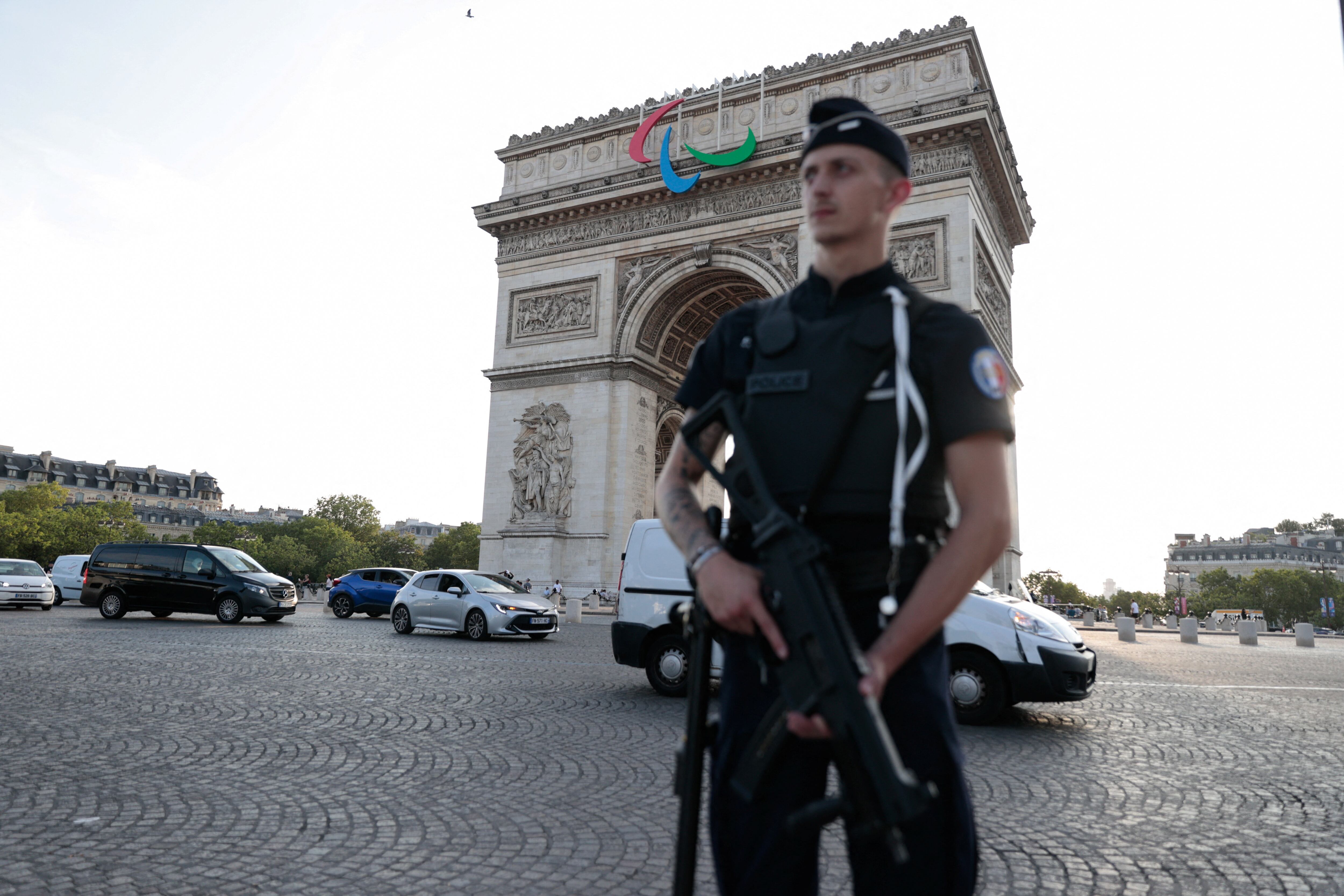 Un miembro de la policía monta guardia con el Arco del Triunfo de fondo en la previa a los Juegos Olímpicos de París (REUTERS/Abdul Saboor)