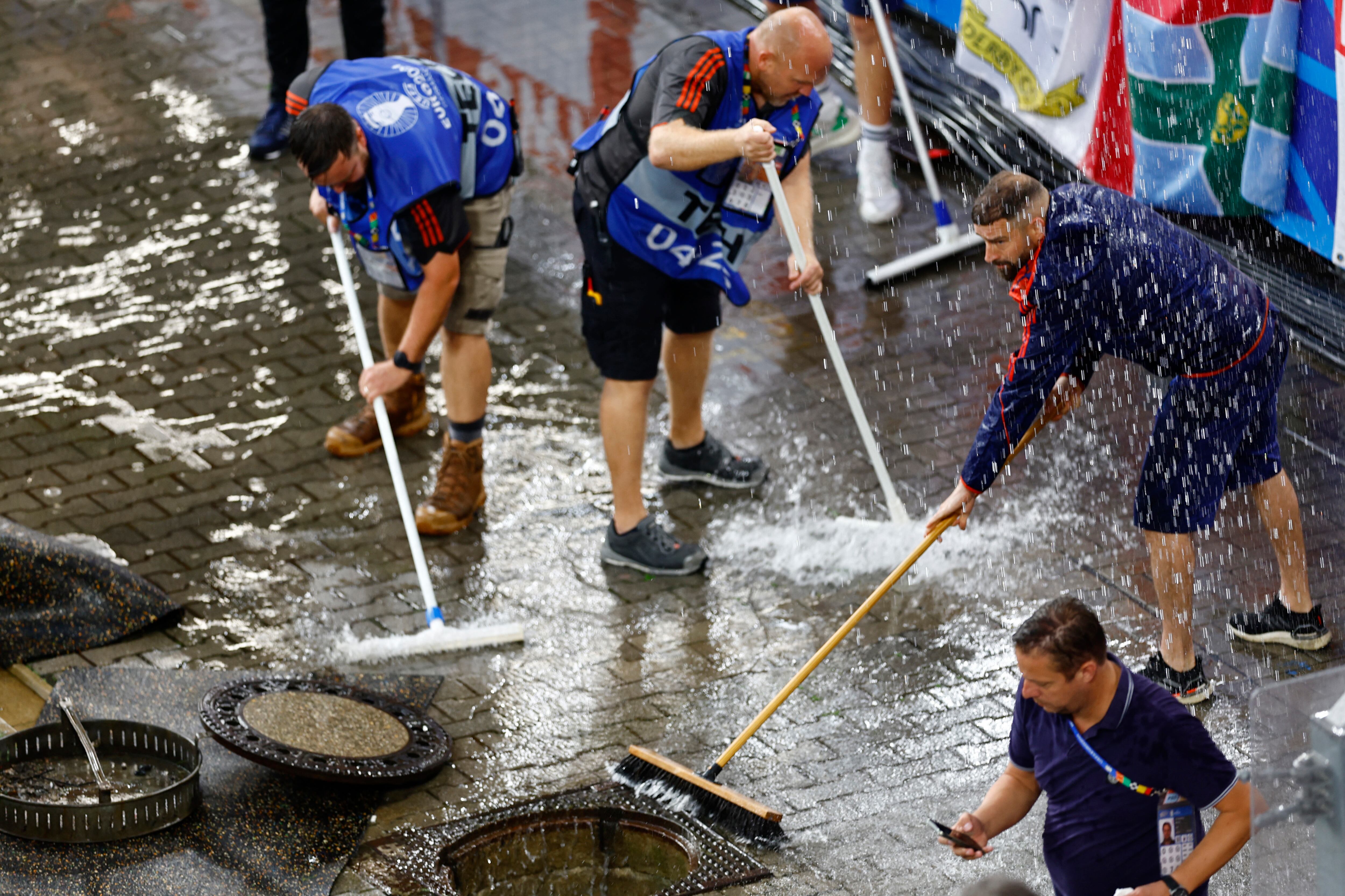 El personal del estadio intenta sacar el agua acumulada por la lluvia torrencial en Dortmund (REUTERS/Leon Kuegeler)