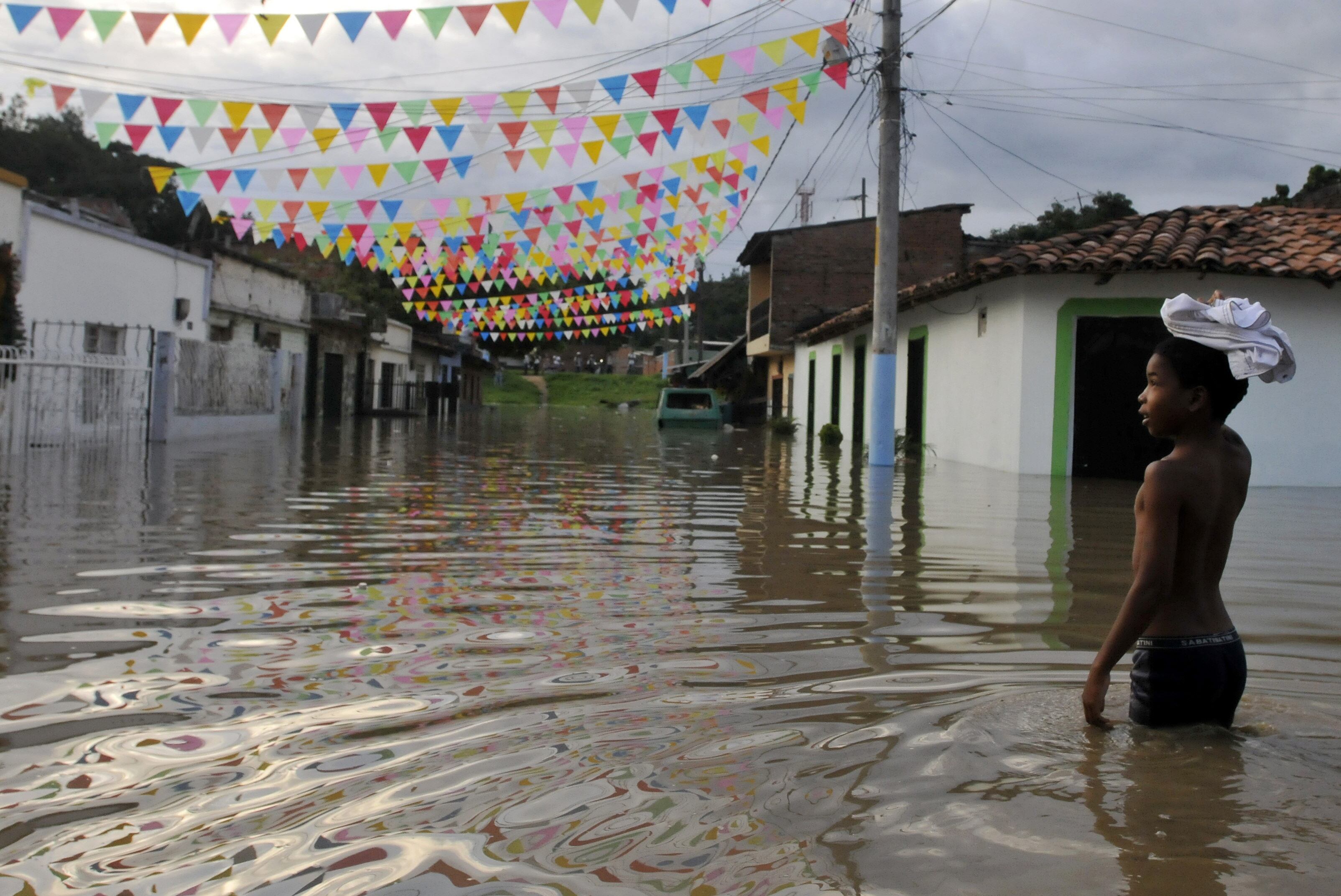 Un niño camina por una calle hoy inundada en Cali (Colombia) como consecuencia del fenómeno climatológico de "La Niña". EFE/CHRISTIAN ESCOBAR MORA
