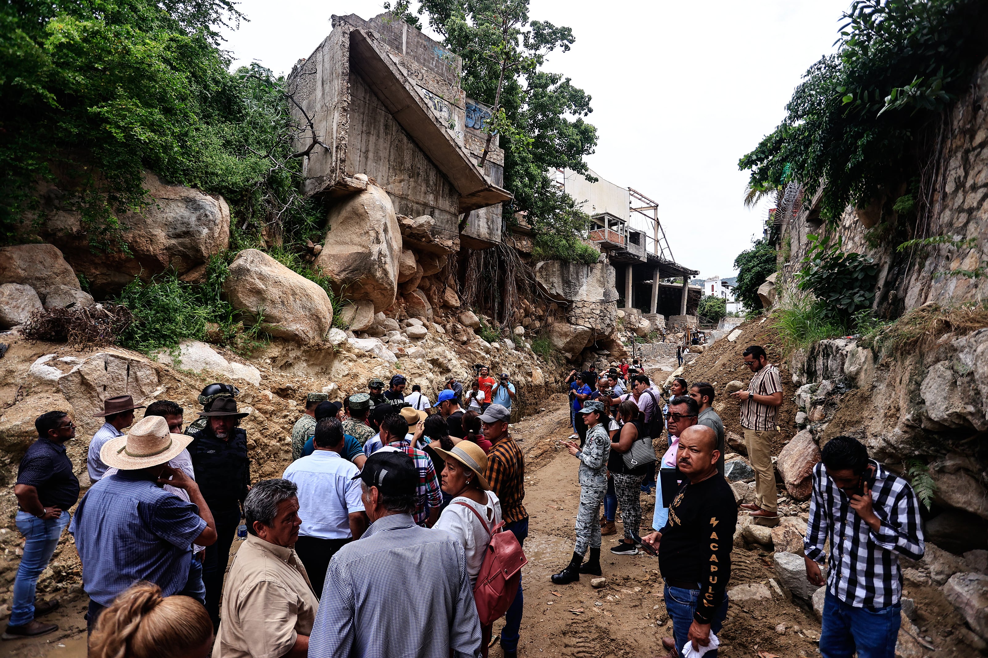 Autoridades municipales y habitantes recorren el canal del río del Camarón donde supervisan la limpieza de los canales por las lluvias del huracán 'Jhon', este lunes, en el ciudad de Acapulco (México). EFE/ David Guzmán
