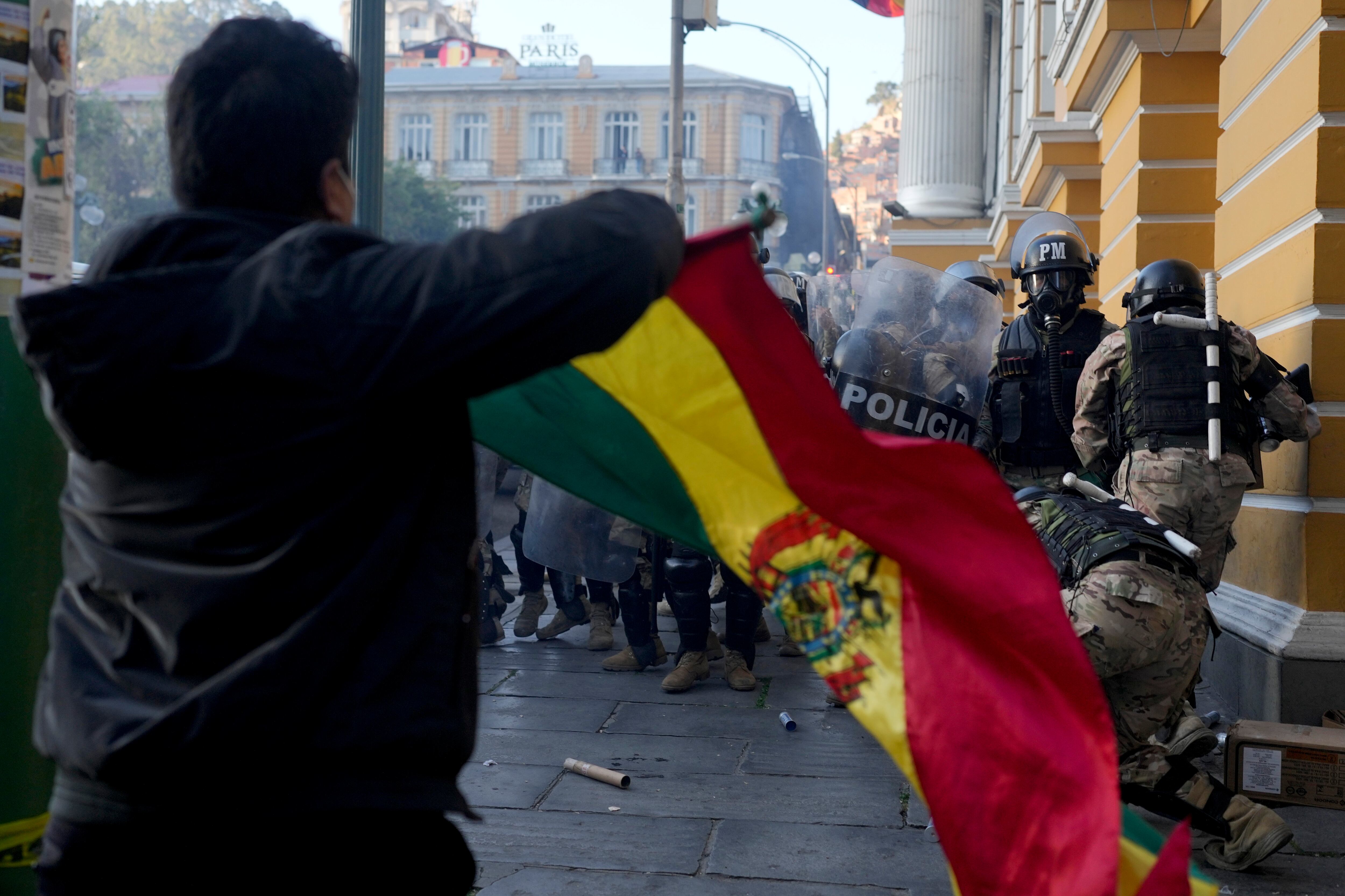 Un seguidor del presidente boliviano, Luis Arce, ondea una bandera de Bolivia ante la retirada de militares de la plaza Murillo, tras un intento de golpe de Estado fallido, en La Paz, Bolivia, el miércoles 26 de junio de 2024. -(AP Foto/Juan Karita)