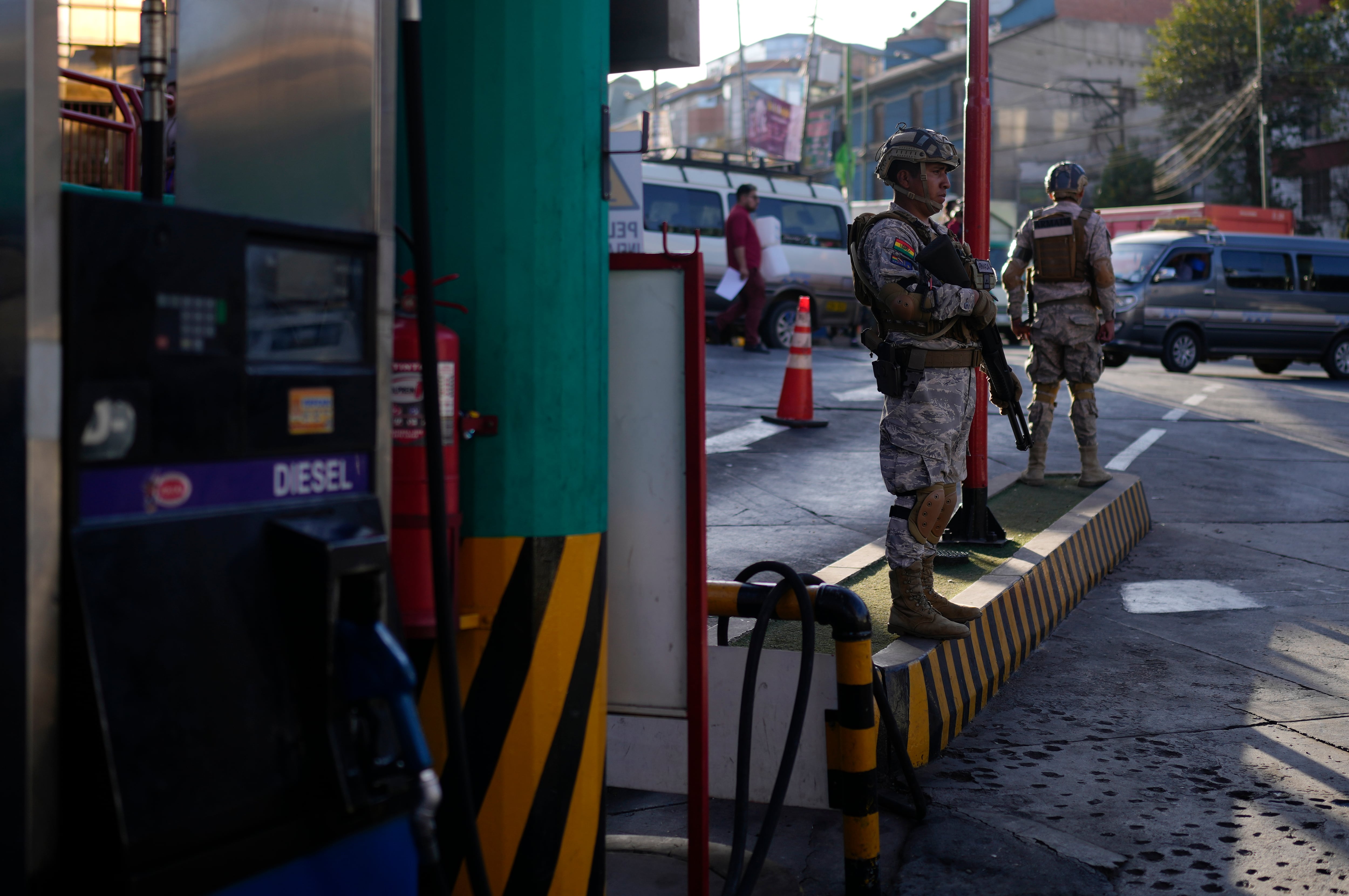 Militares hacen guardia en una gasolinera por disposición del gobierno para supervisar las estaciones de gasolina y evitar que el combustible salga de contrabando, en La Paz, Bolivia, el miércoles 12 de junio de 2024. (AP Foto/Juan Karita)