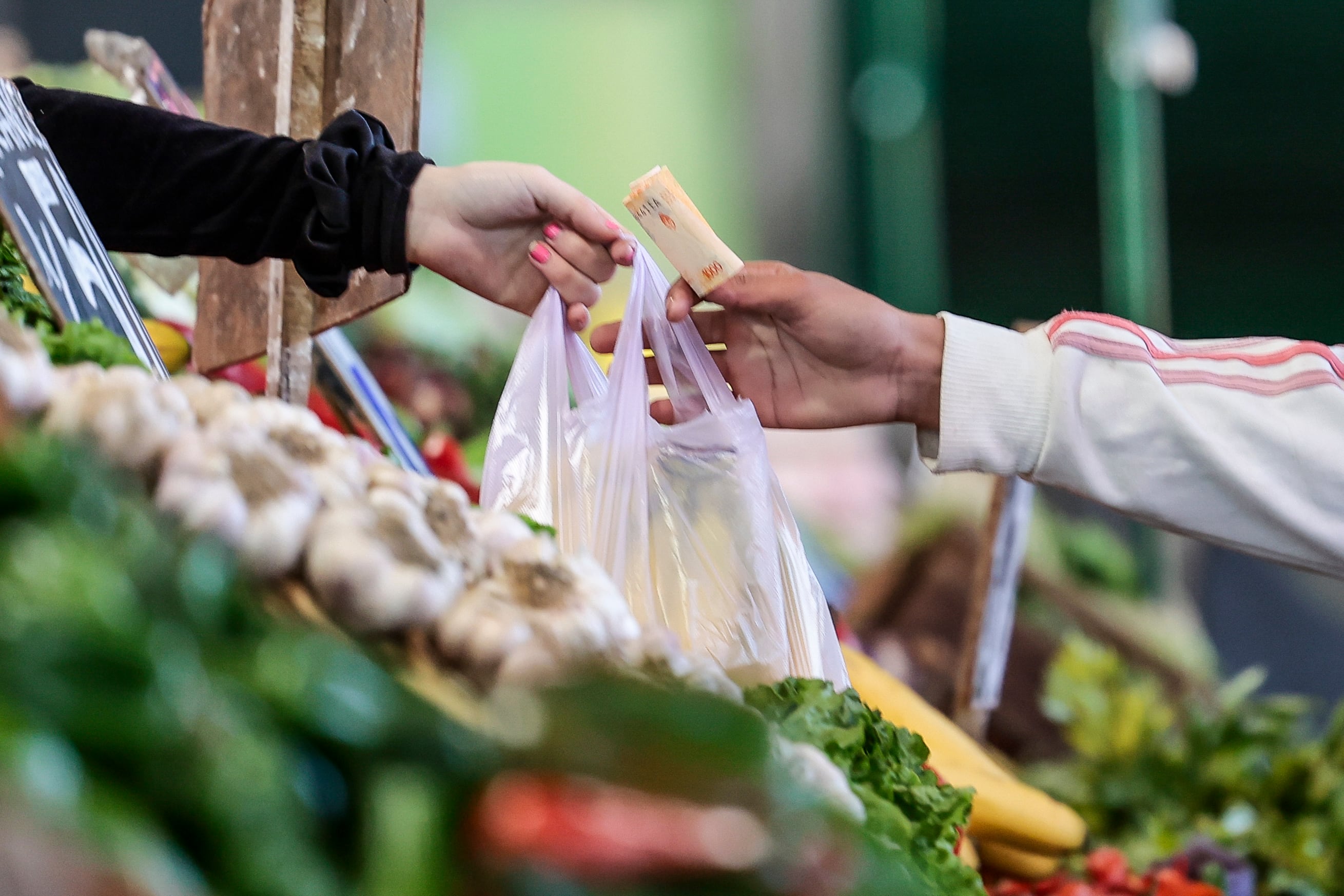 Fotografía de archivo en la que se registraron las manos de una vendedora y un comprador de alimentos, en el mercado Central de Frutas y Verduras, en la localidad de Tapiales. EFE/Juan Ignacio Roncoroni
