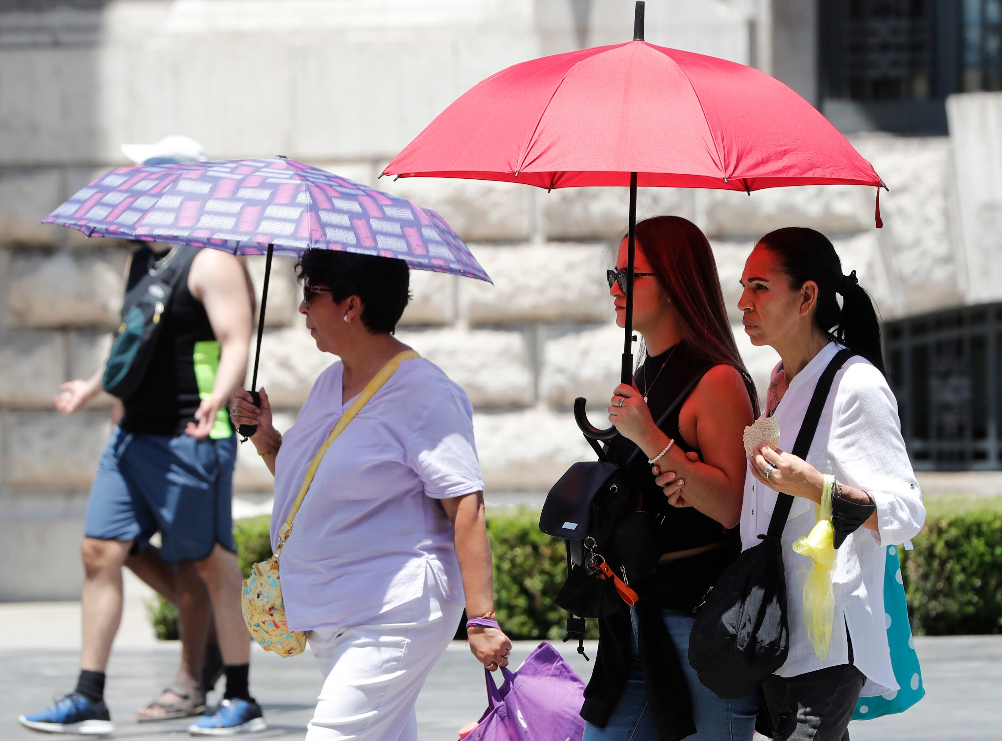 Personas se cubren del intenso calor con sombrillas el viernes en la Ciudad de México (México). EFE/Mario Guzmán
