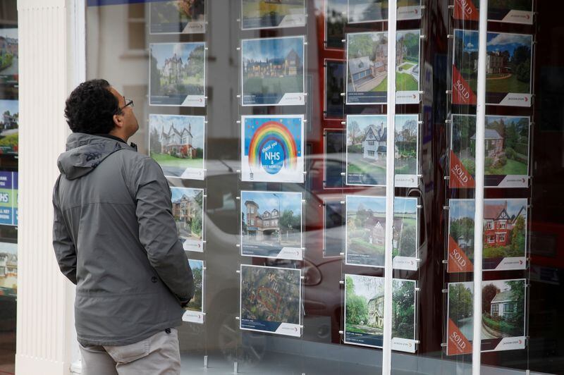 Un hombre mira los anuncios de pisos en venta en el escaparate de una inmobiliaria. (Phil Noble/Reuters)