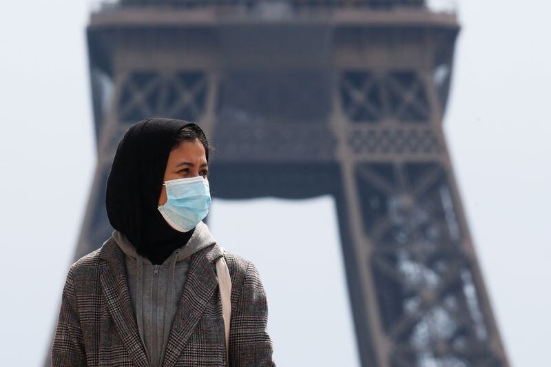 Una mujer con hiyab y mascarilla anda por la plaza de Trocadero, junto a la torre Eiffel de París, Francia. 2 mayo 2021. REUTERS/Gonzalo Fuentes