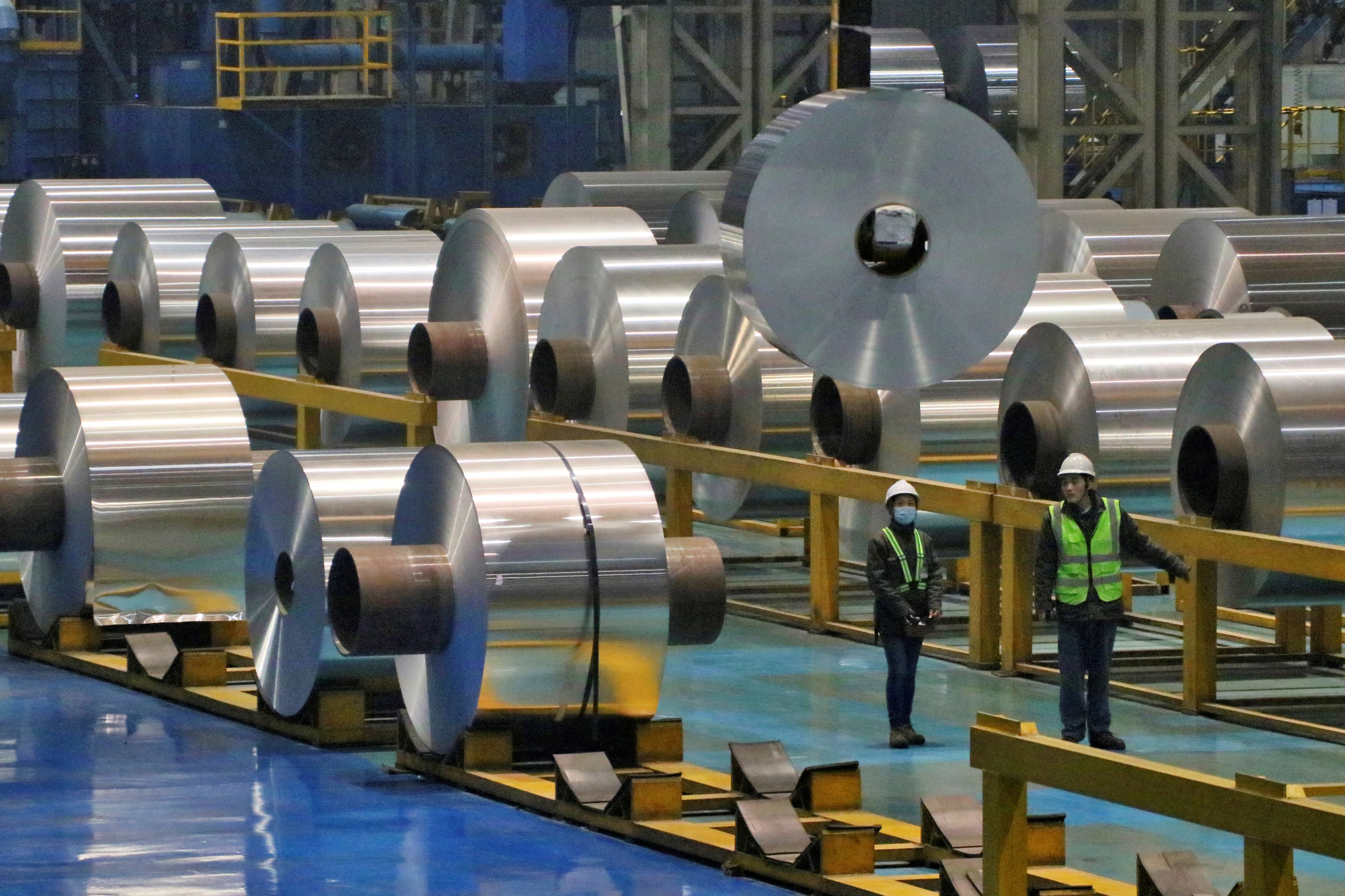 Empleados trabajan en la línea de producción de rollos de aluminio en una fábrica en Zouping, provincia de Shandong, China (REUTERS)