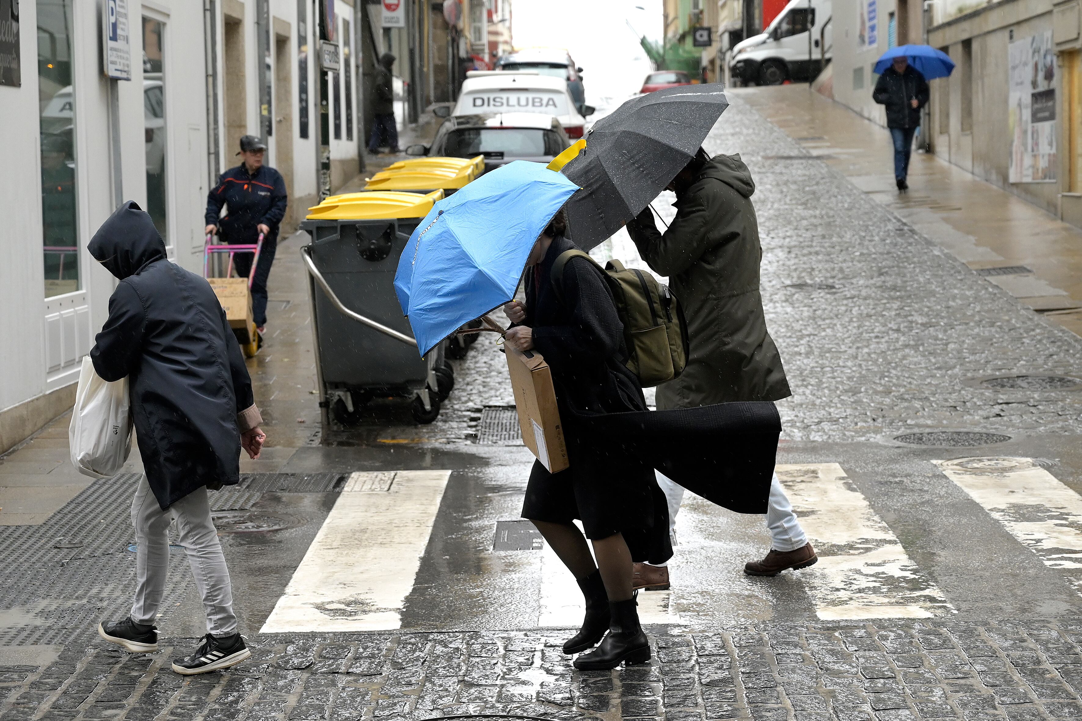 Foto de archivo de varias personas protegiéndose de la lluvia (M. Dylan/Europa Press)