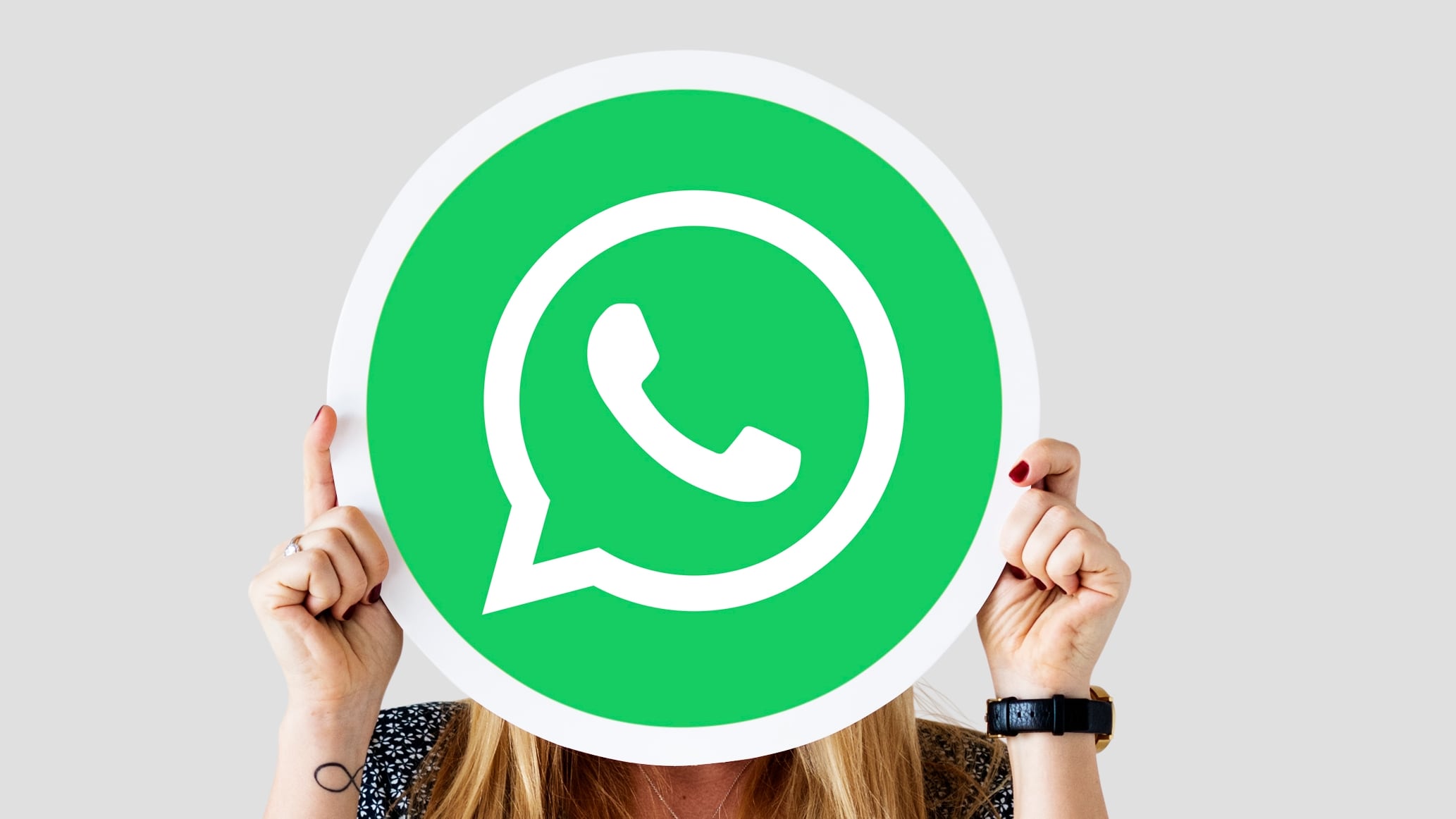 Una mujer sujeta el logo de whatsApp. (FREEPIK)