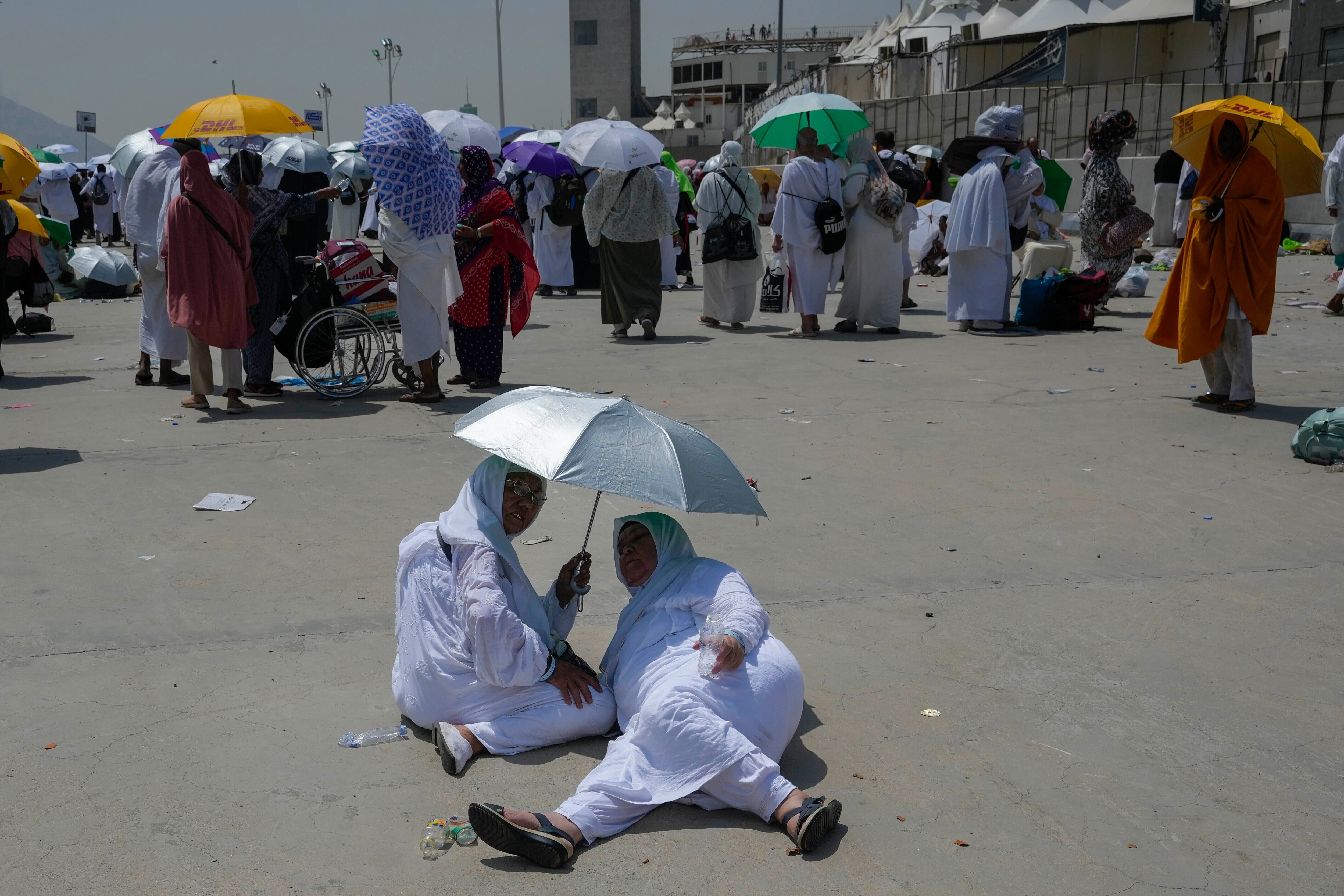 Dos peregrinas musulmanas se protegen del sol cerca de los pilares donde se realiza la lapidación simbólica del diablo, el último ritual del haj, en Mina, cerca de La Meca (AP Foto/Rafiq Maqbool)