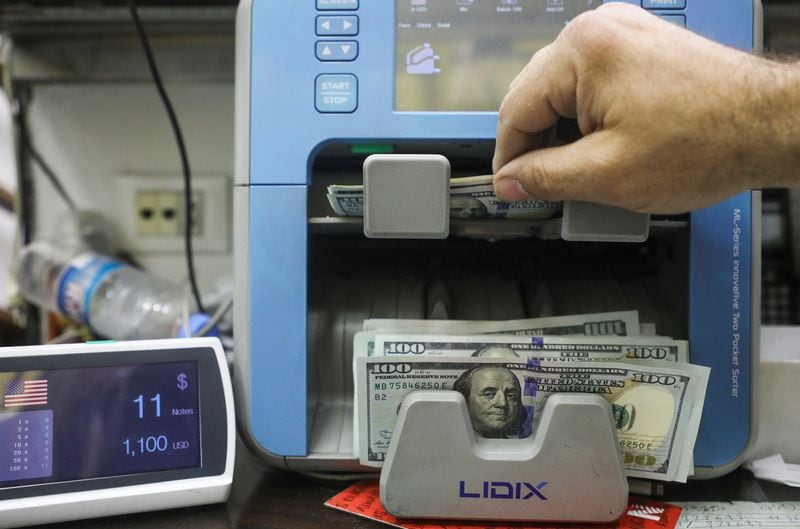 Un hombre cuenta billetes de dólares estadounidenses en una casa de cambio en Beirut, Líbano, el 18 de marzo de 2022. (REUTERS/Mohamed Azakir)