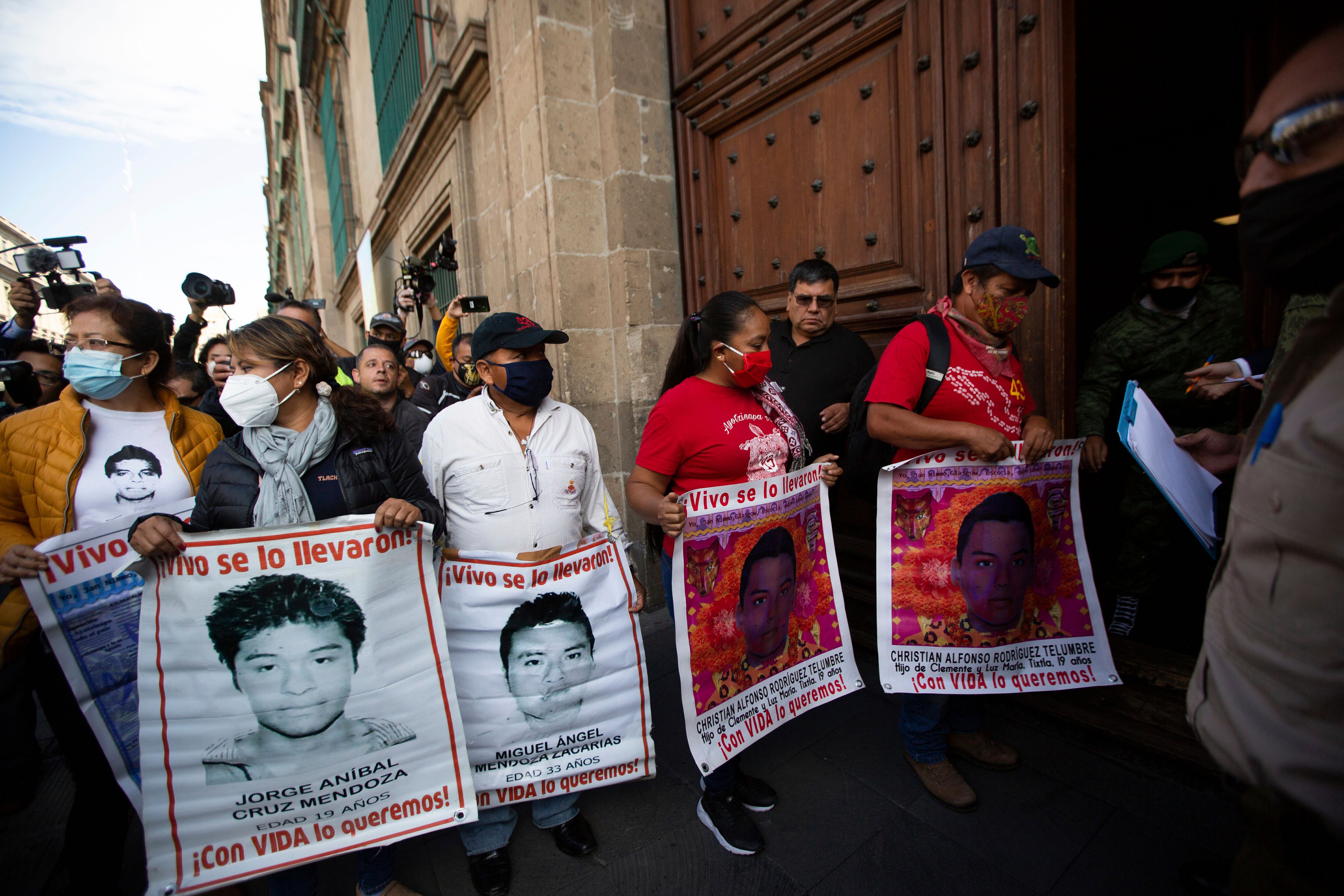 ARCHIVO - Padres con las fotos de sus hijos desaparecidos que son parte de los 43 estudiantes de la Escuela Rural Normal de Ayotzinapa, en el estado de Guerrero, entran al palacio nacional. (AP Foto/Fernando Llano, Archivo)