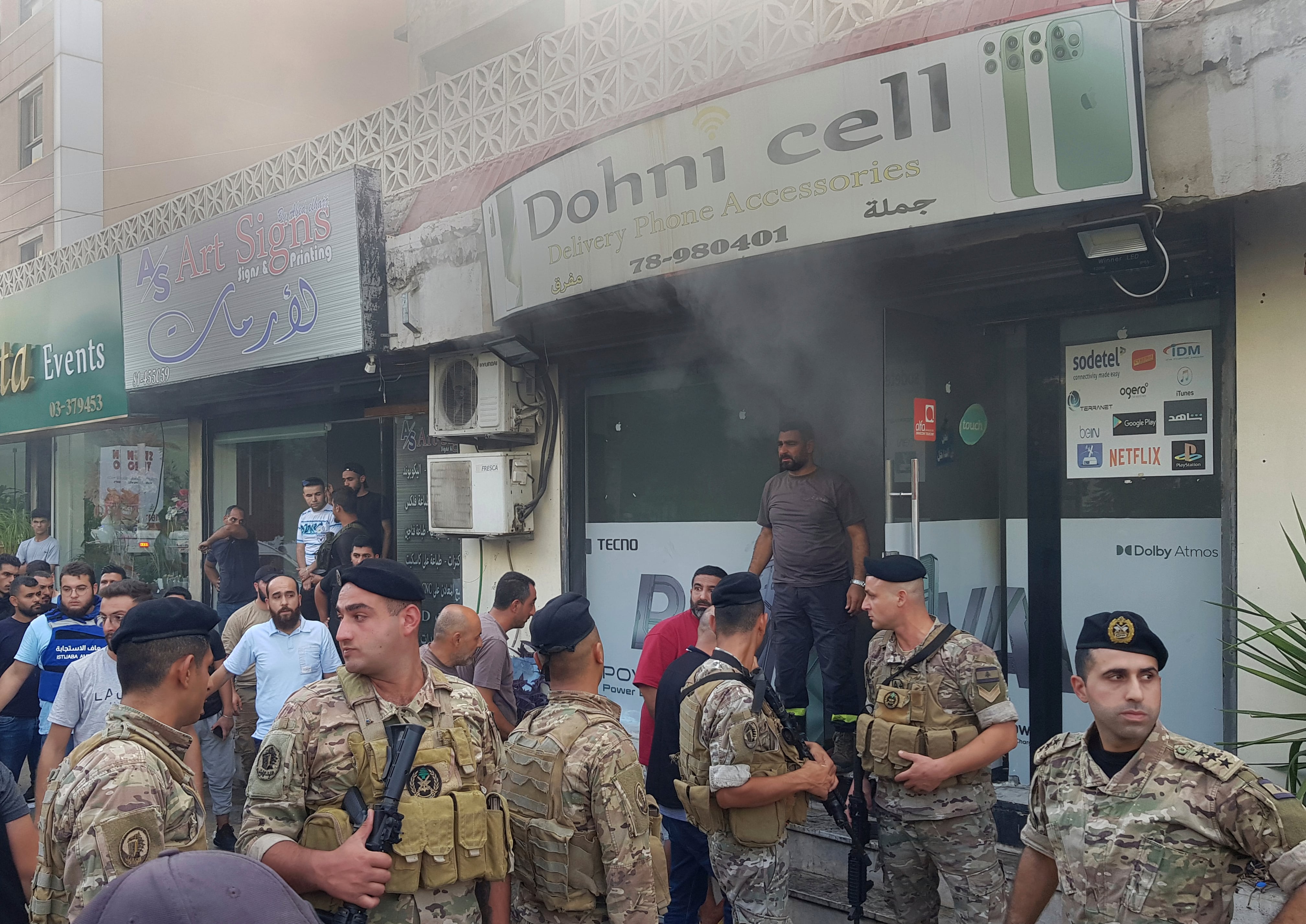 Soldados libaneses se congregan afuera de una tienda de celulares dañada luego de lo que se cree que fue el resultado de una explosión de walkie-talkie en su interior  (AP Foto/Mohammed Zaatari)