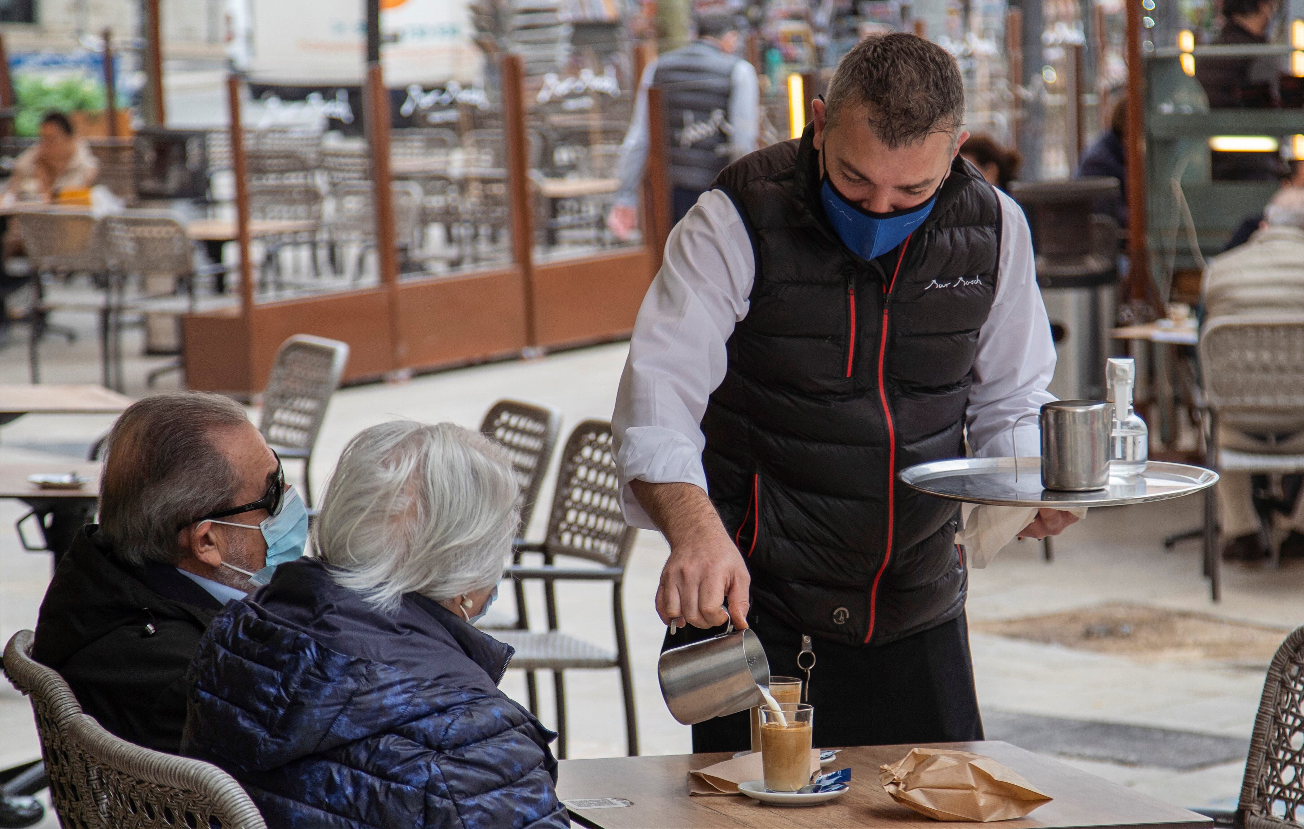 Una pareja se toma un café en la terraza de un bar . (Ezequiel Iván Espinar Riutort/EFE)
