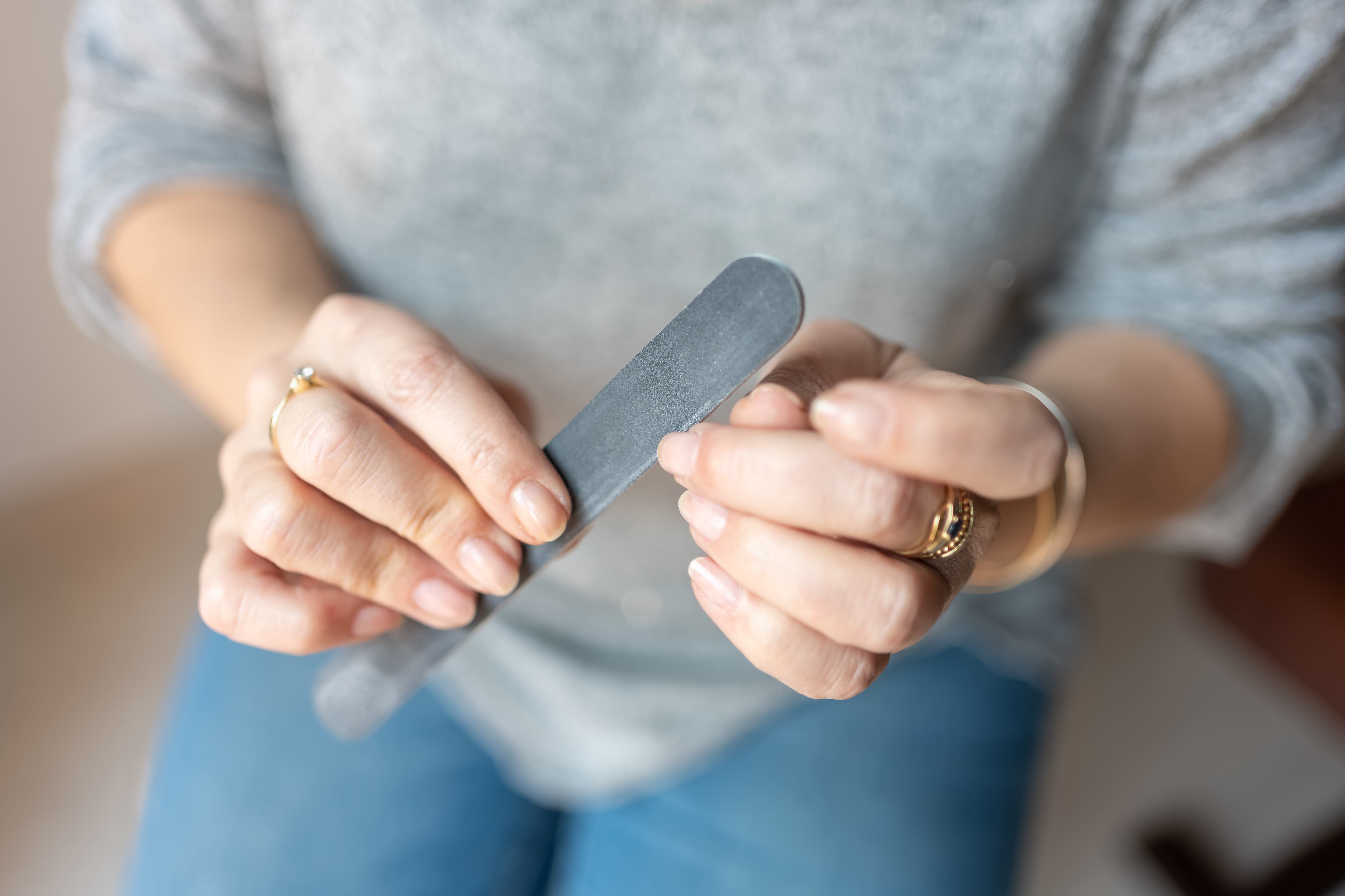 Una mujer se lima las uñas (Shutterstock España)