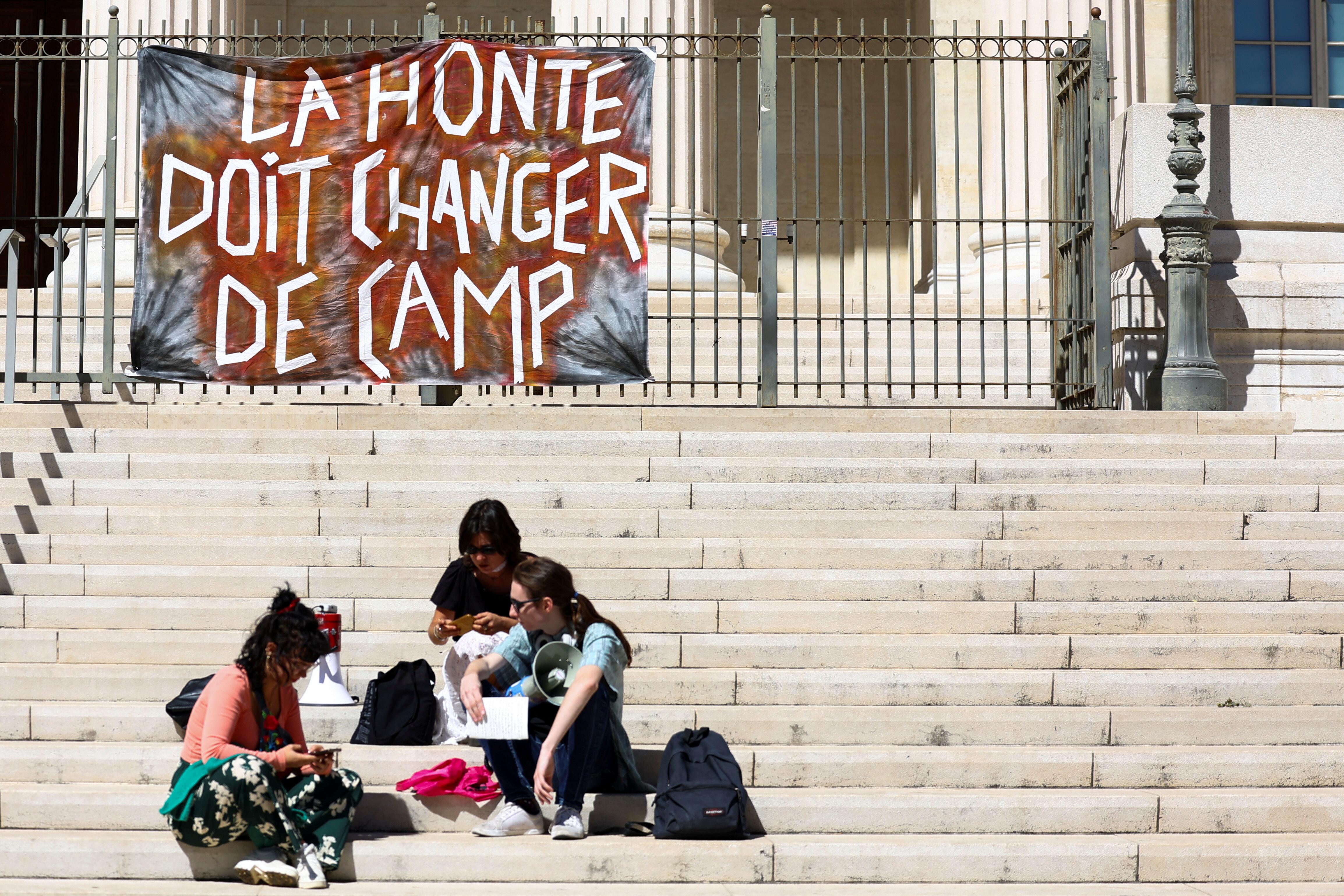 "La vergüenza debe cambiar de lado", dice el cartel que se ve arriba de la escalinata, en los preparativos de una marcha en apoyo de Gisele Pelicot en Marsella, el pasado 14 de septiembre (REUTERS/Manon Cruz)