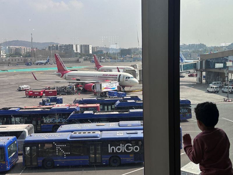 Un niño observa los aviones de pasajeros de la aerolínea Air India estacionados en el Aeropuerto Internacional Chhatrapati Shivaji Maharaj de Mumbai, India. 1 de febrero de 2024 (Reuters)