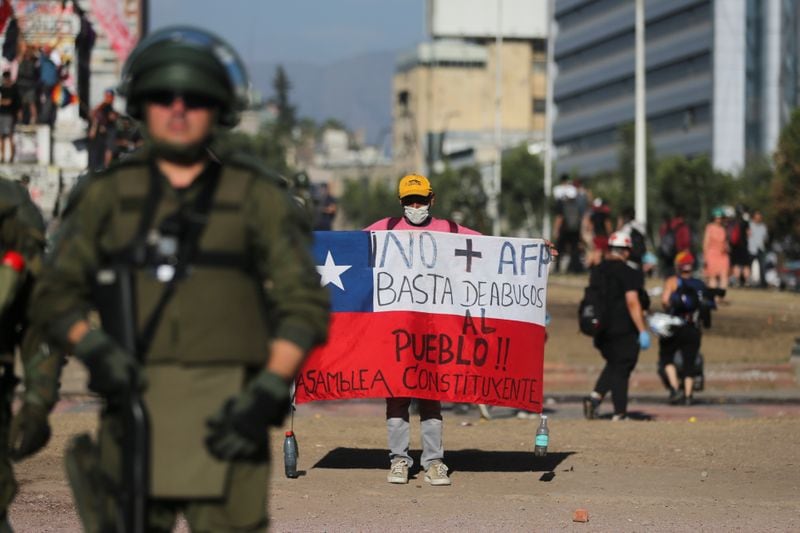 Un manifestante sujeta una pancarta de "No+AFP" en contra del sistema privado de pensiones durante una protesta en Santiago, en noviembre de 2019 (REUTERS/Pilar Olivares)