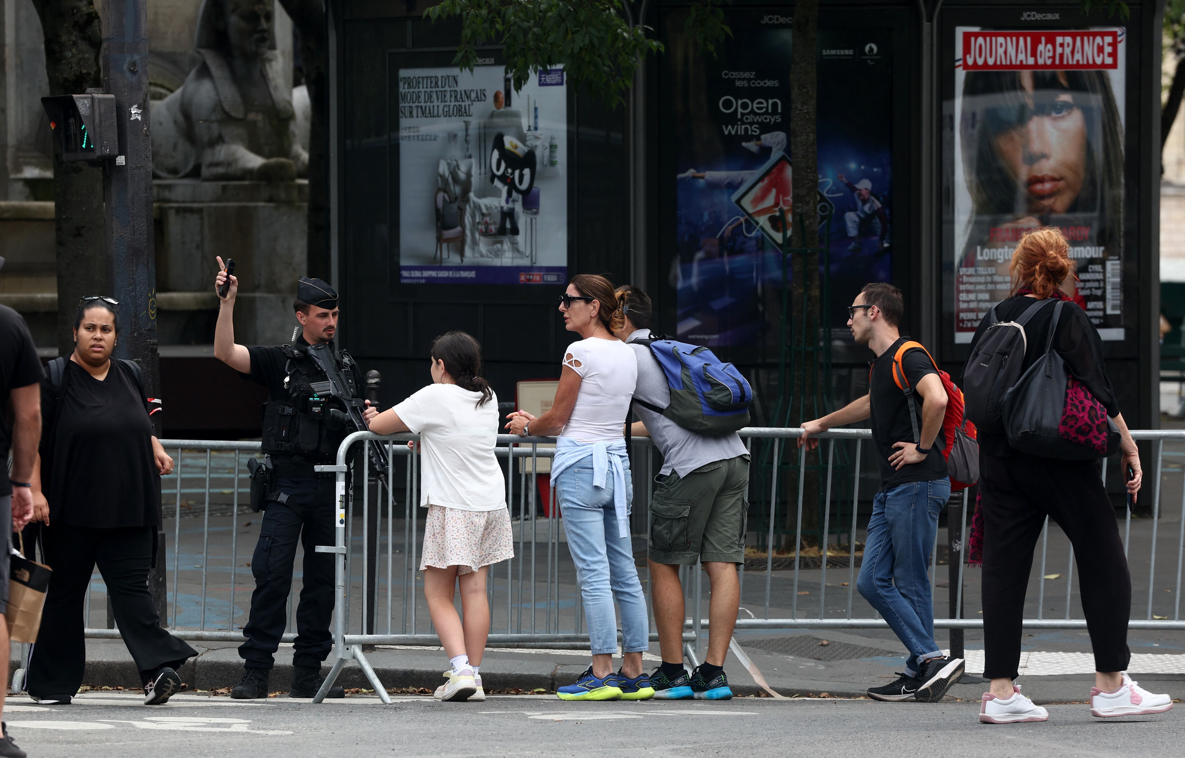 Un gendarme le indica a los peatones los lugares por donde podrán circular en las calles de París (REUTERS/Yves Herman)