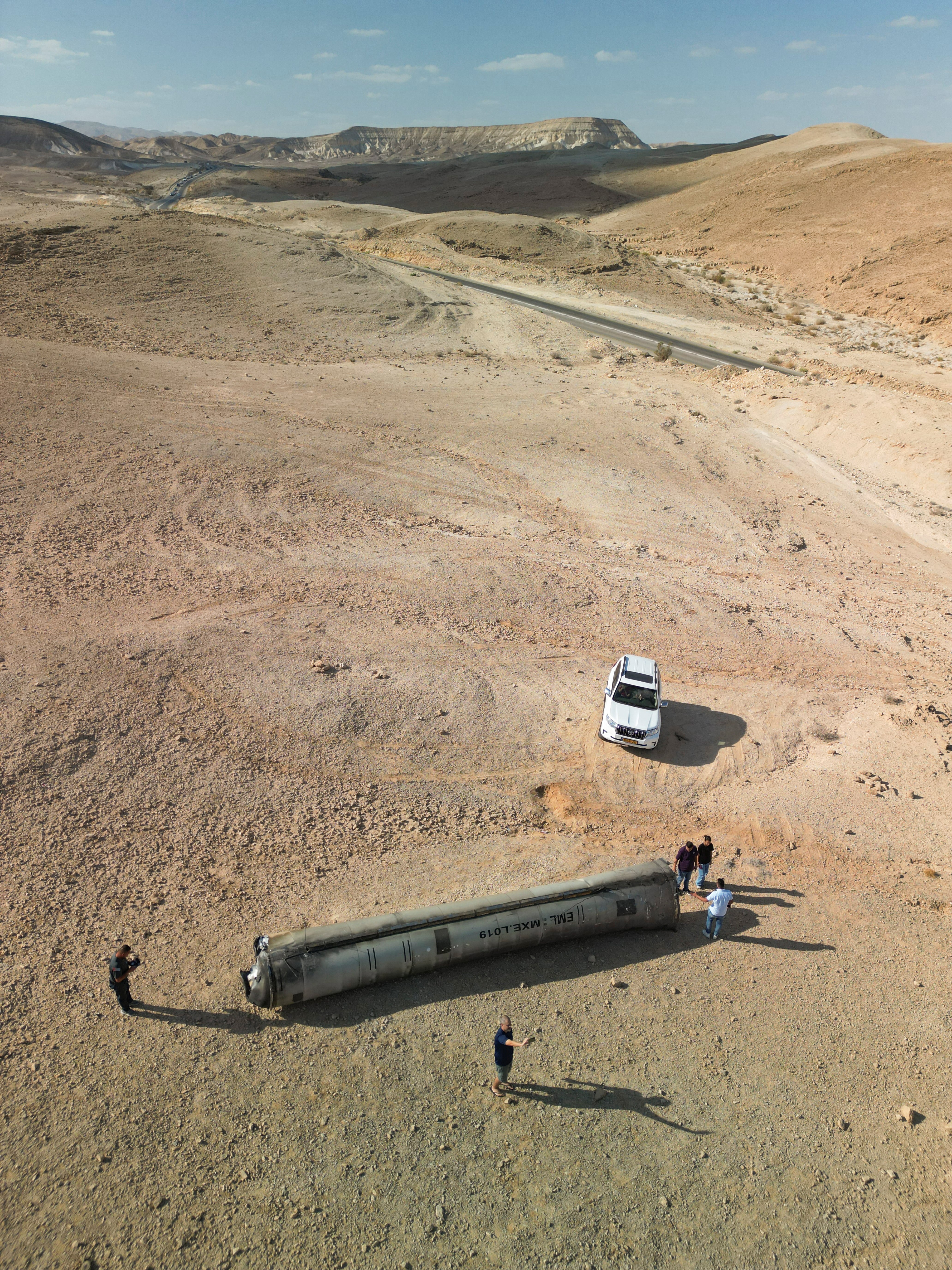 Una vista de un dron muestra a personas paradas alrededor de los aparentes restos de un misil balístico que yacen en el desierto, luego de un ataque de Irán contra Israel, cerca de la ciudad sureña de Arad, Israel, el 2 de octubre de 2024. REUTERS/