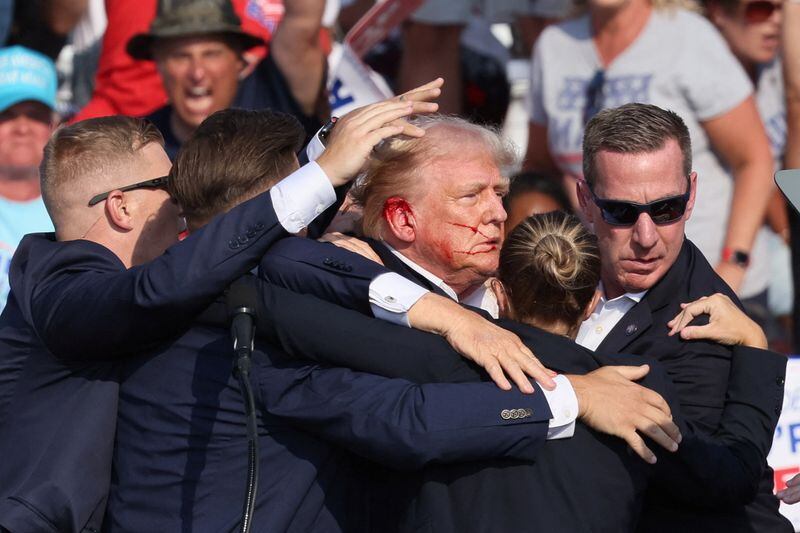 El candidato presidencial republicano y expresidente de Estados Unidos Donald Trump gesticula con la cara ensangrentada mientras suenan múltiples disparos durante un mitin de campaña en el Butler Farm Show en Butler, Pensilvania July 13, 2024. REUTERS/Brendan McDermid